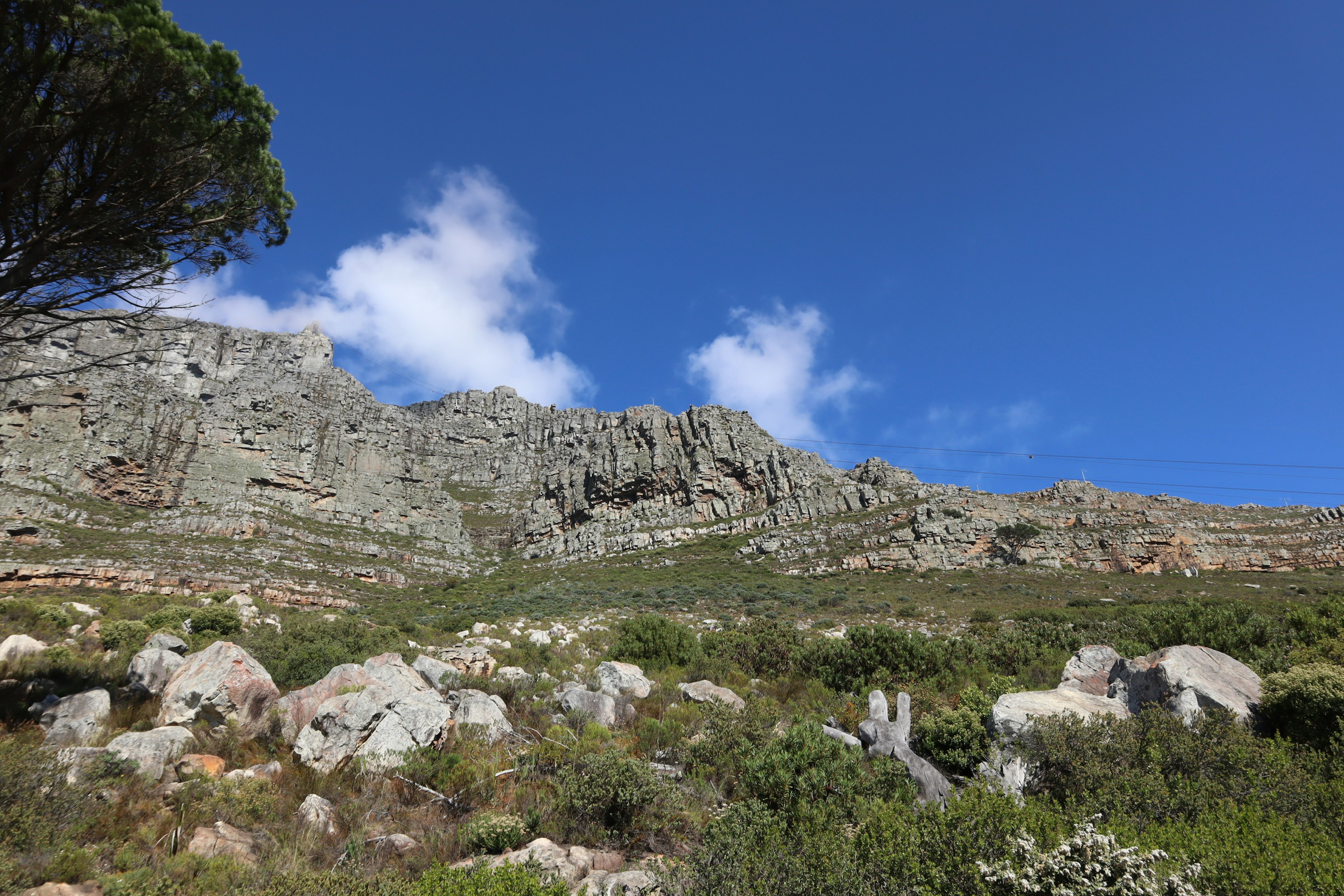 Dramatische Berglandschaft mit blauem Himmel grünem Gras und verstreuten Steinen