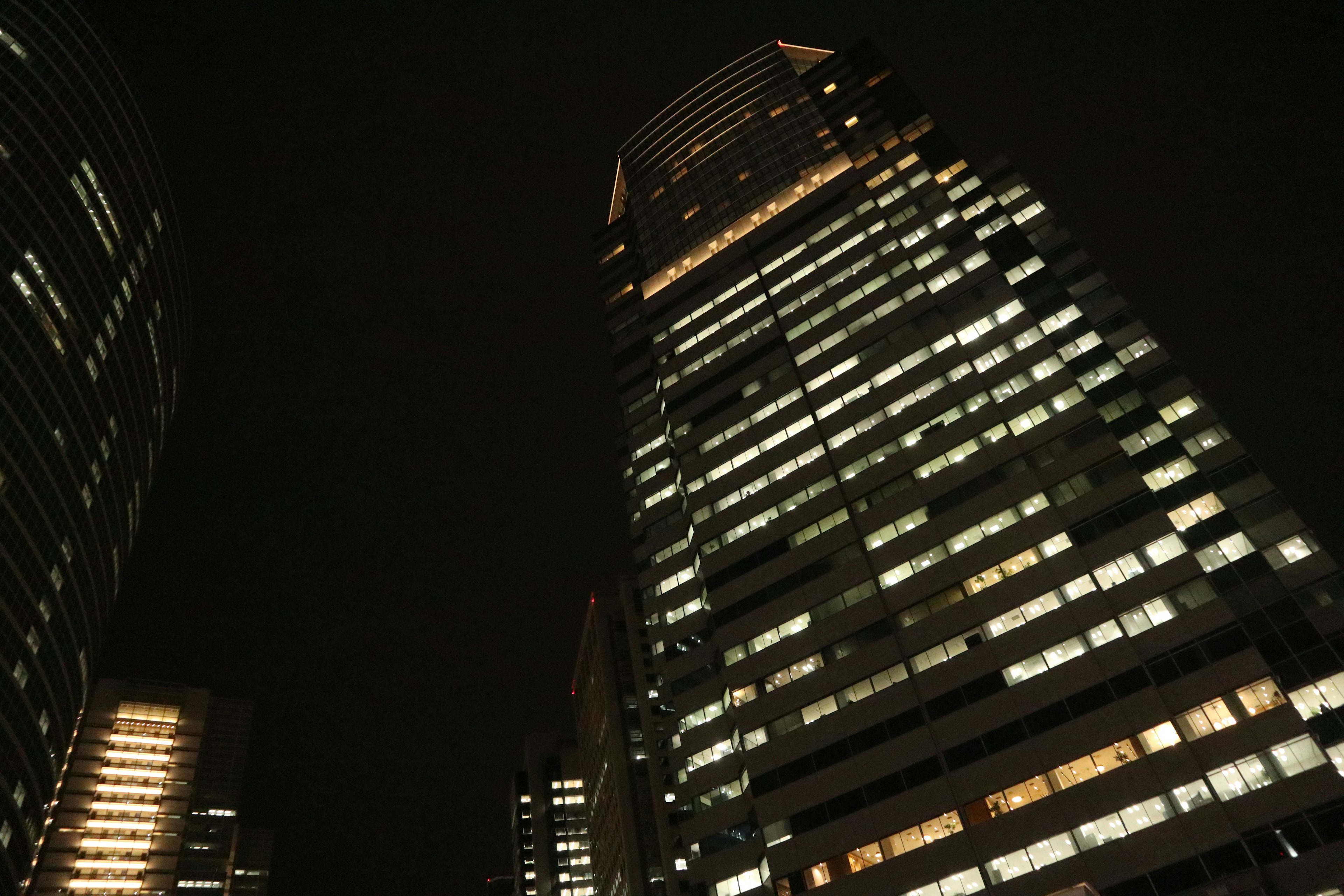 Gedung pencakar langit dalam pemandangan kota malam dengan jendela yang terang