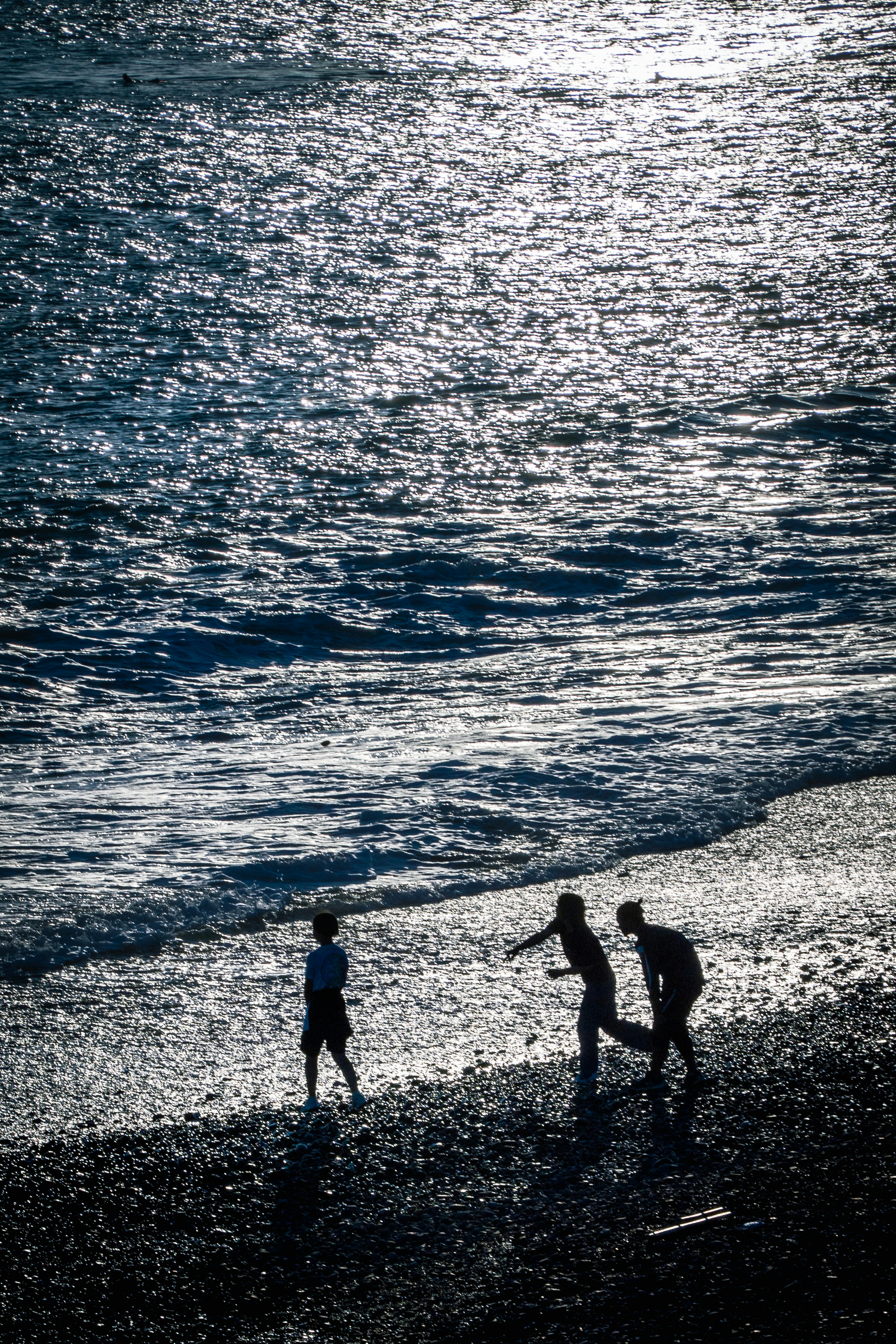 Silhouette anak-anak bermain di pantai