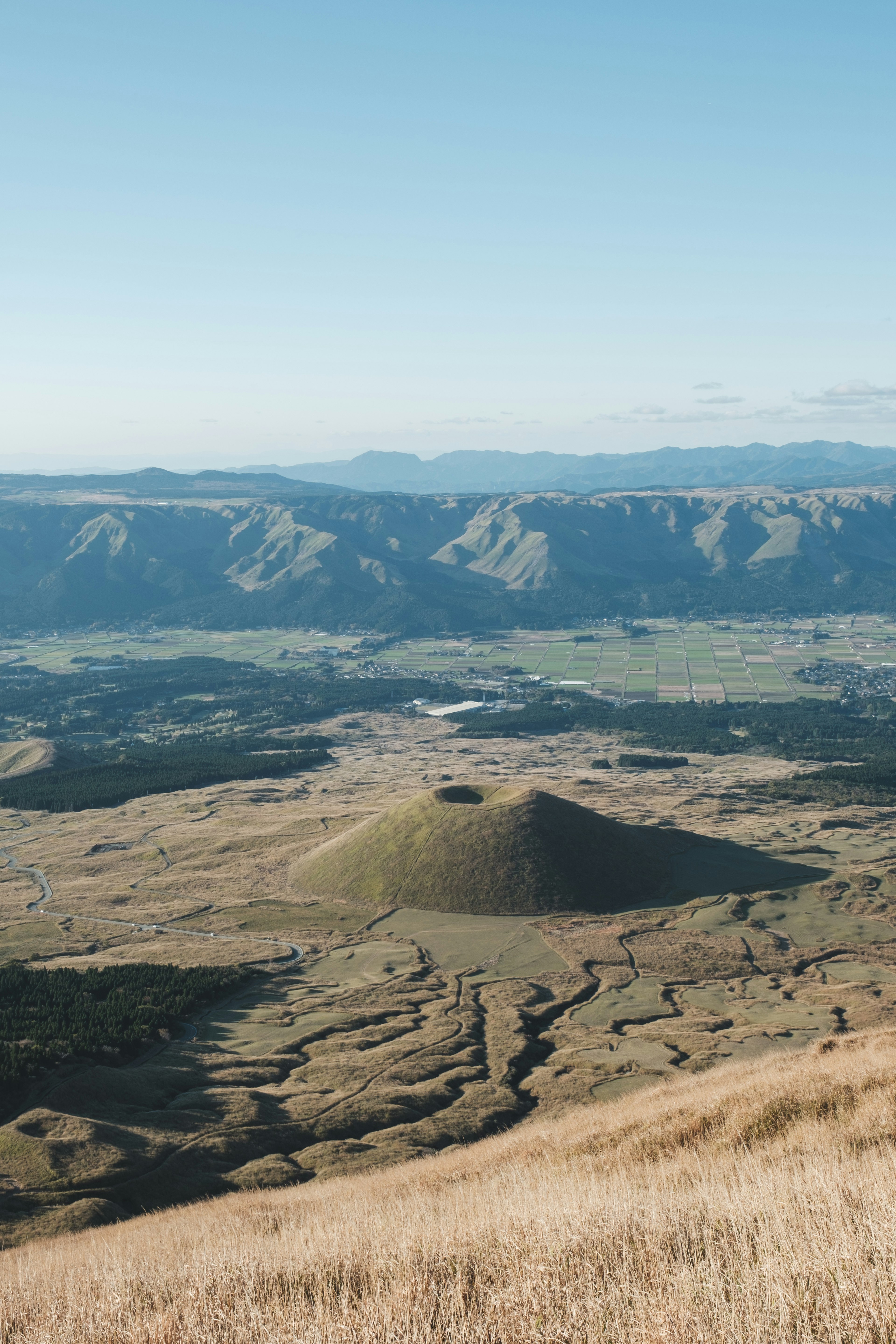 Vast grasslands and mountains with a small hill in the foreground