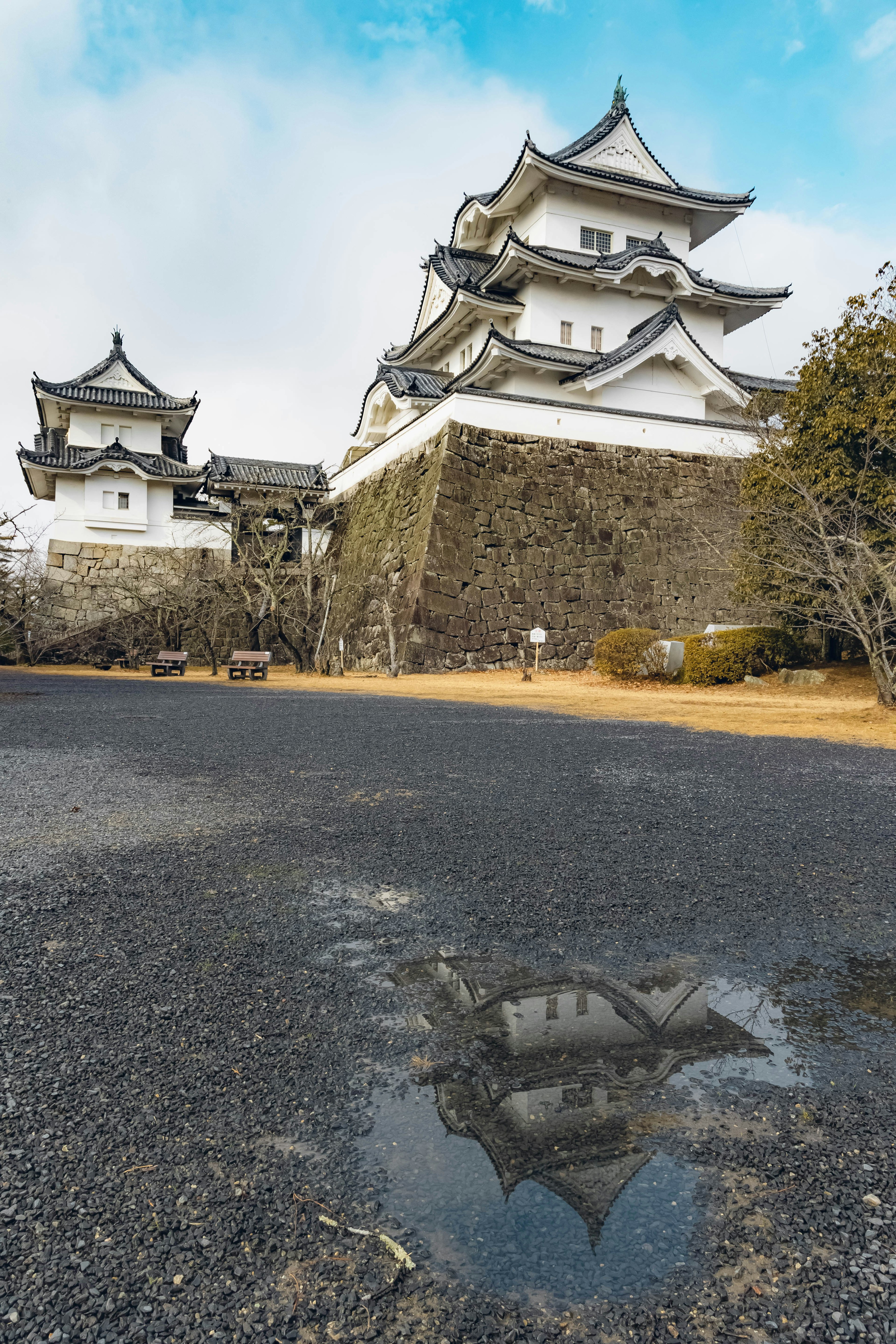 White castle with a reflection visible in a puddle on the road