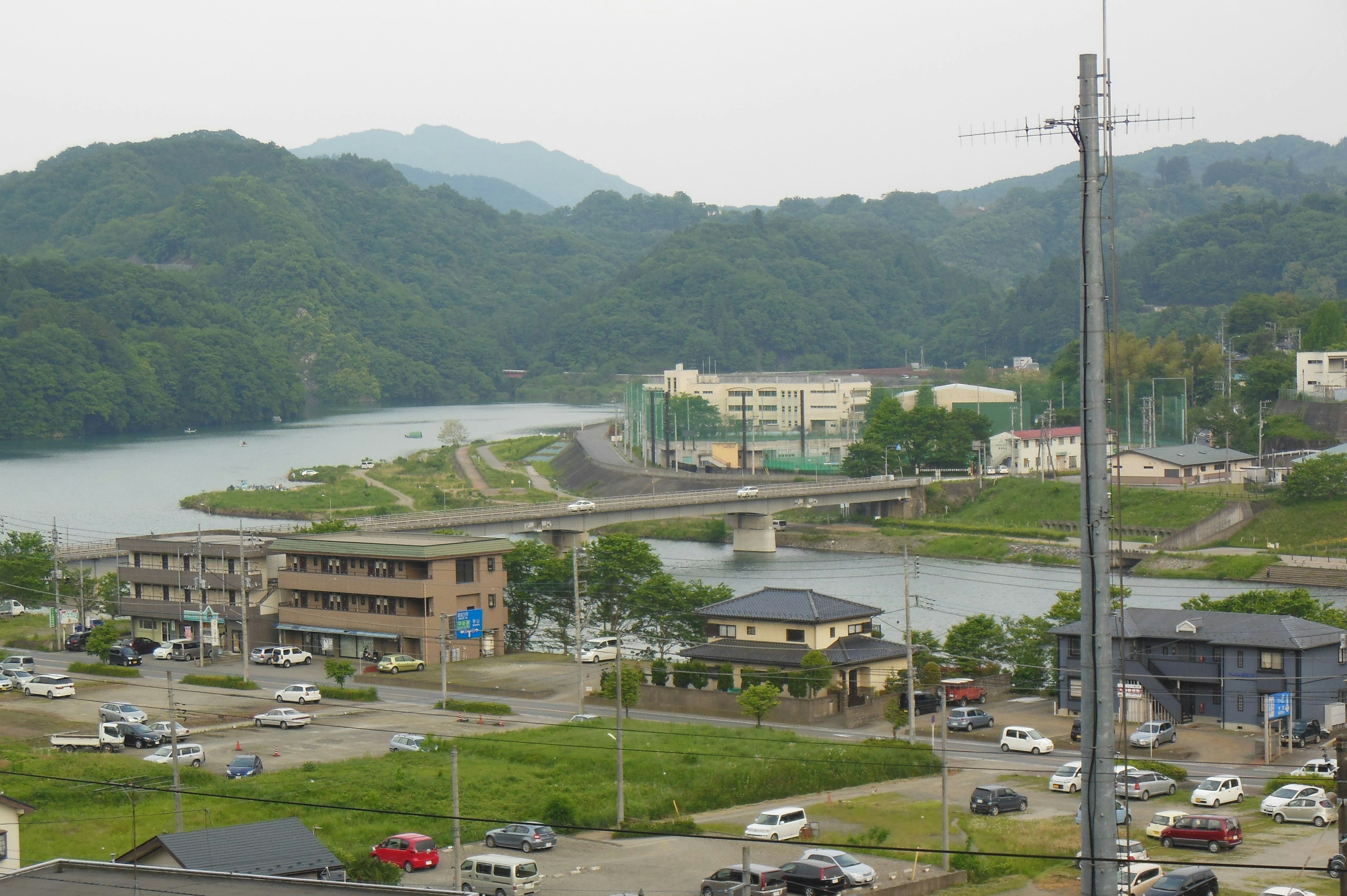 Vue panoramique d'une rivière bordée de collines avec un pont