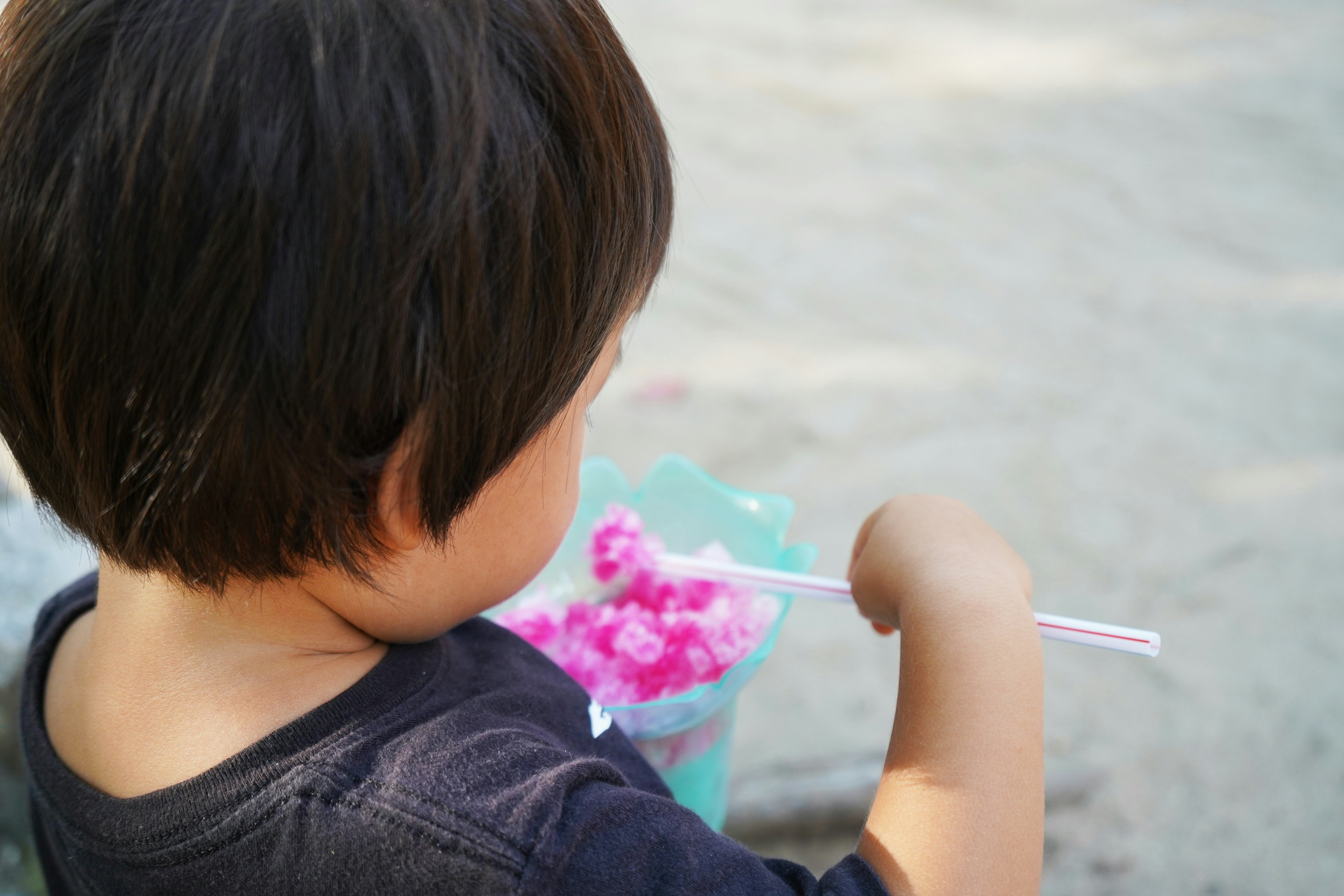 Bambino che gusta cotone zuccherato rosa