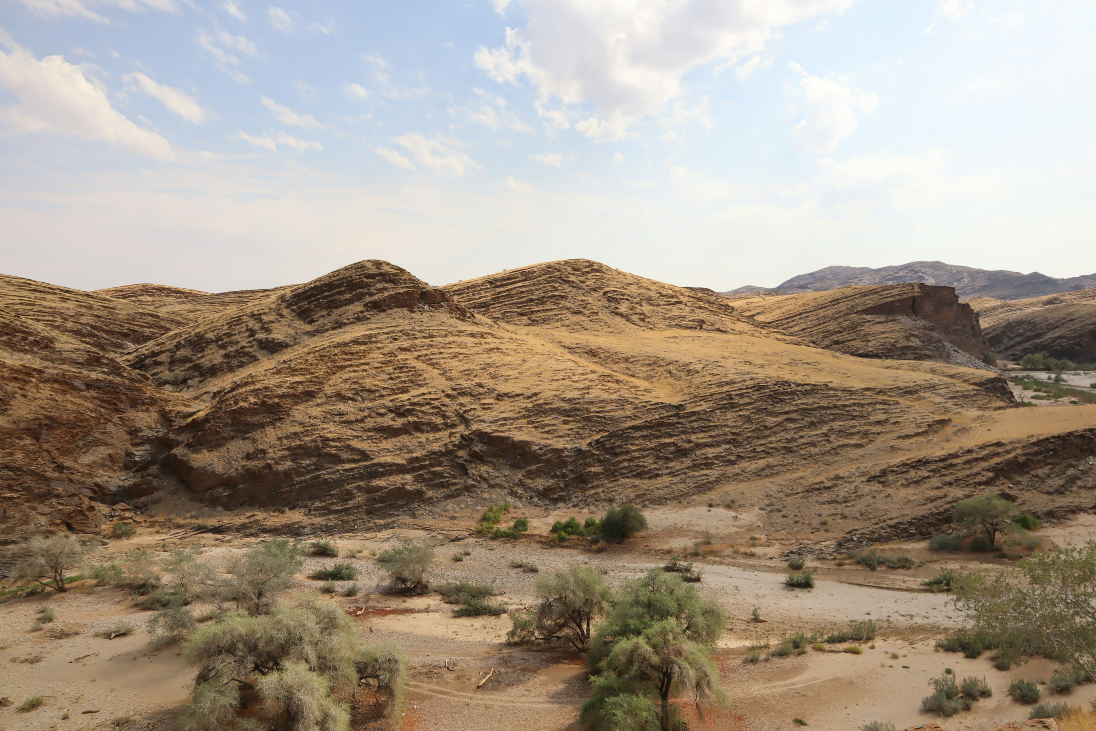 Paisaje montañoso seco con colinas cubiertas de hierba