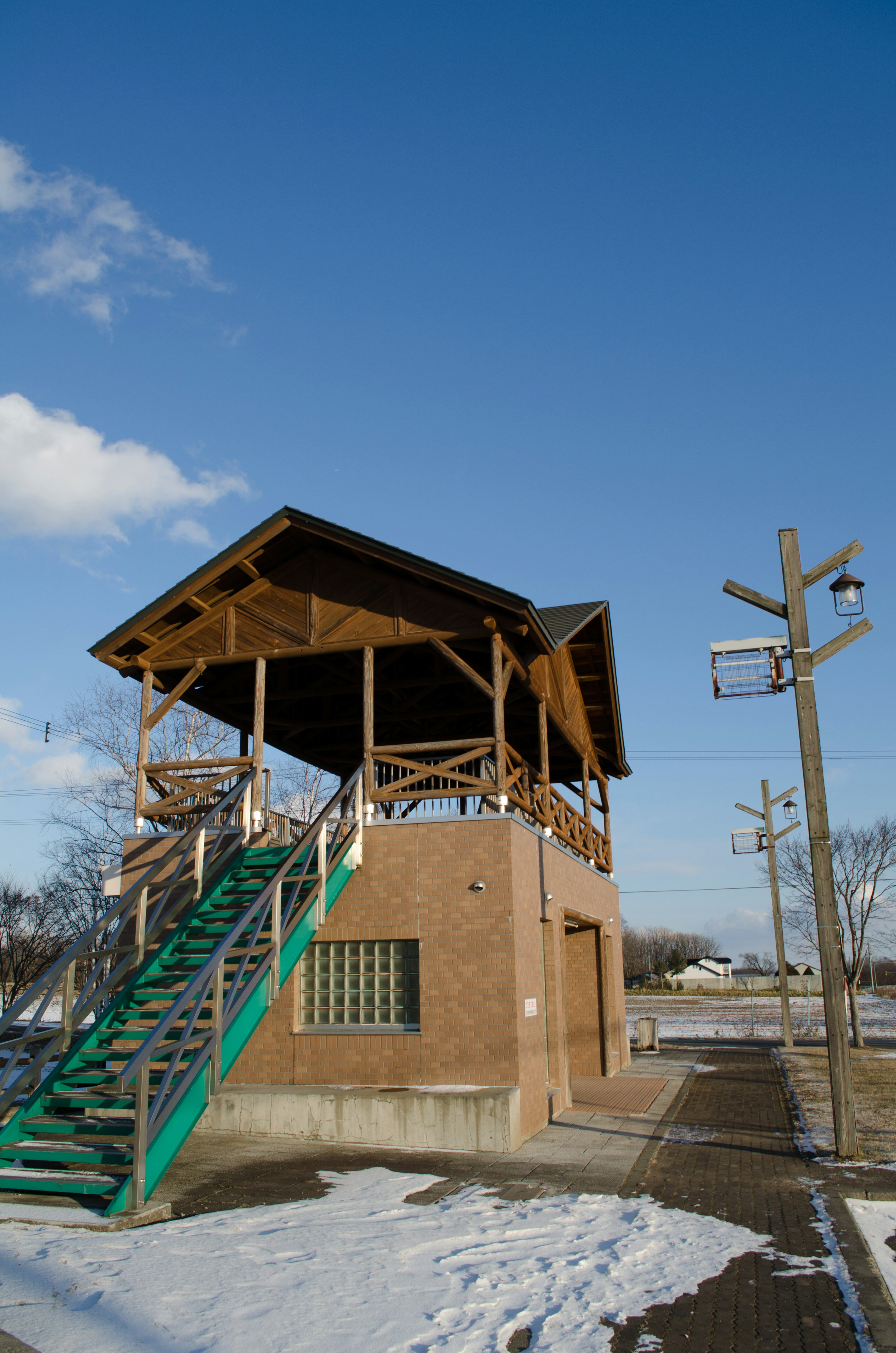 Wooden structure with green stairs on snowy ground