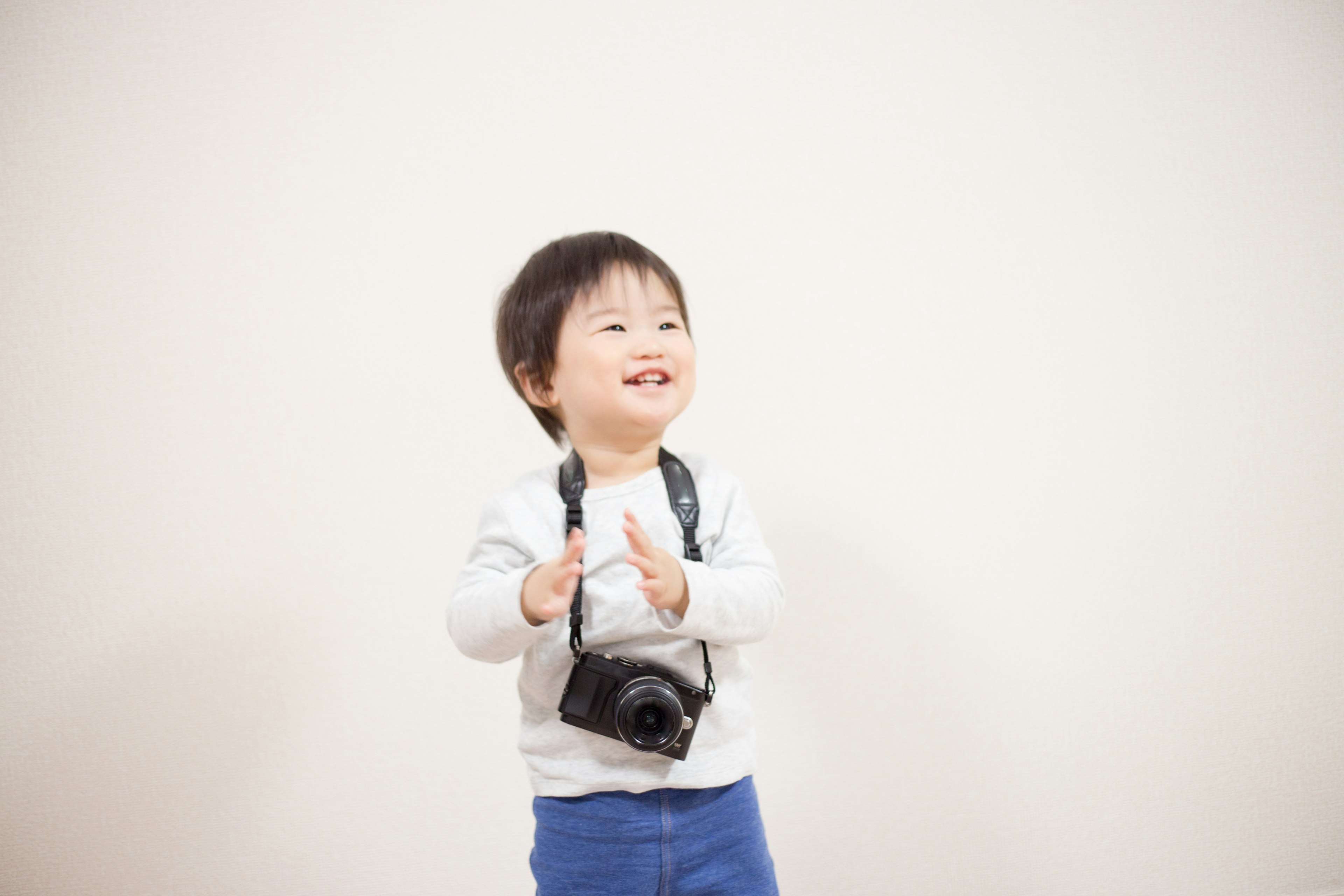 Smiling child standing with a camera around their neck