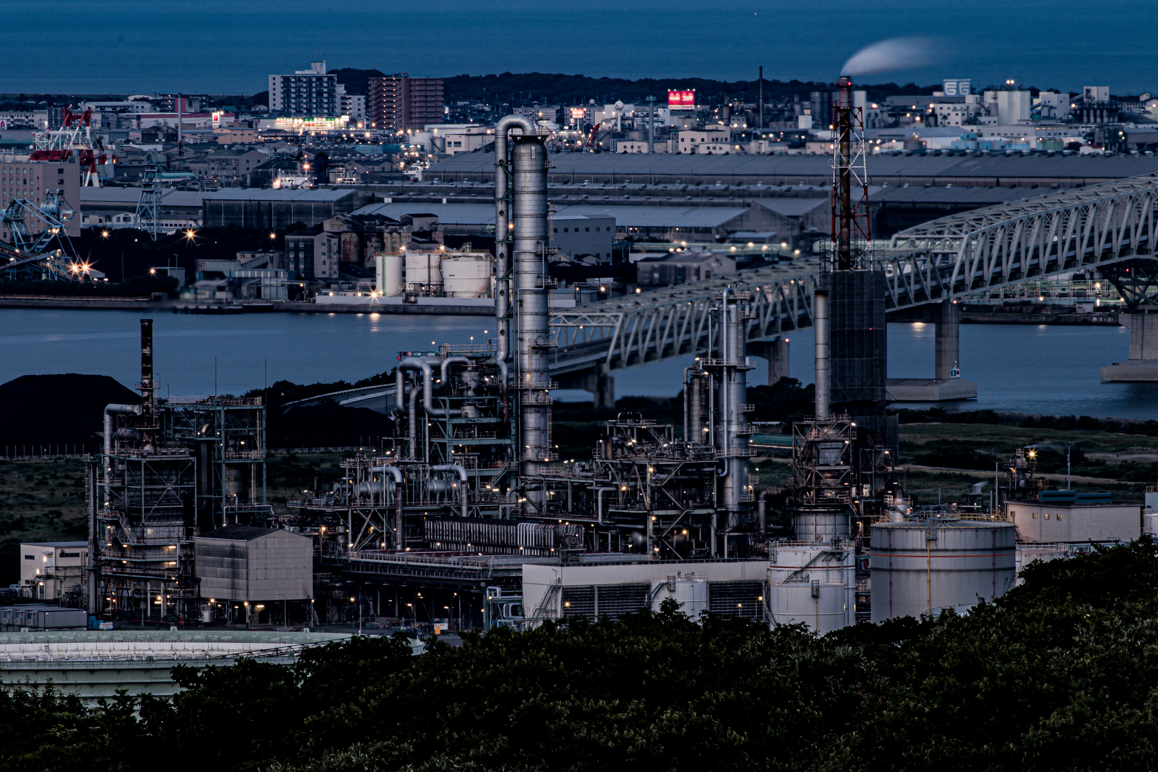 Vista nocturna de una zona industrial con un puente