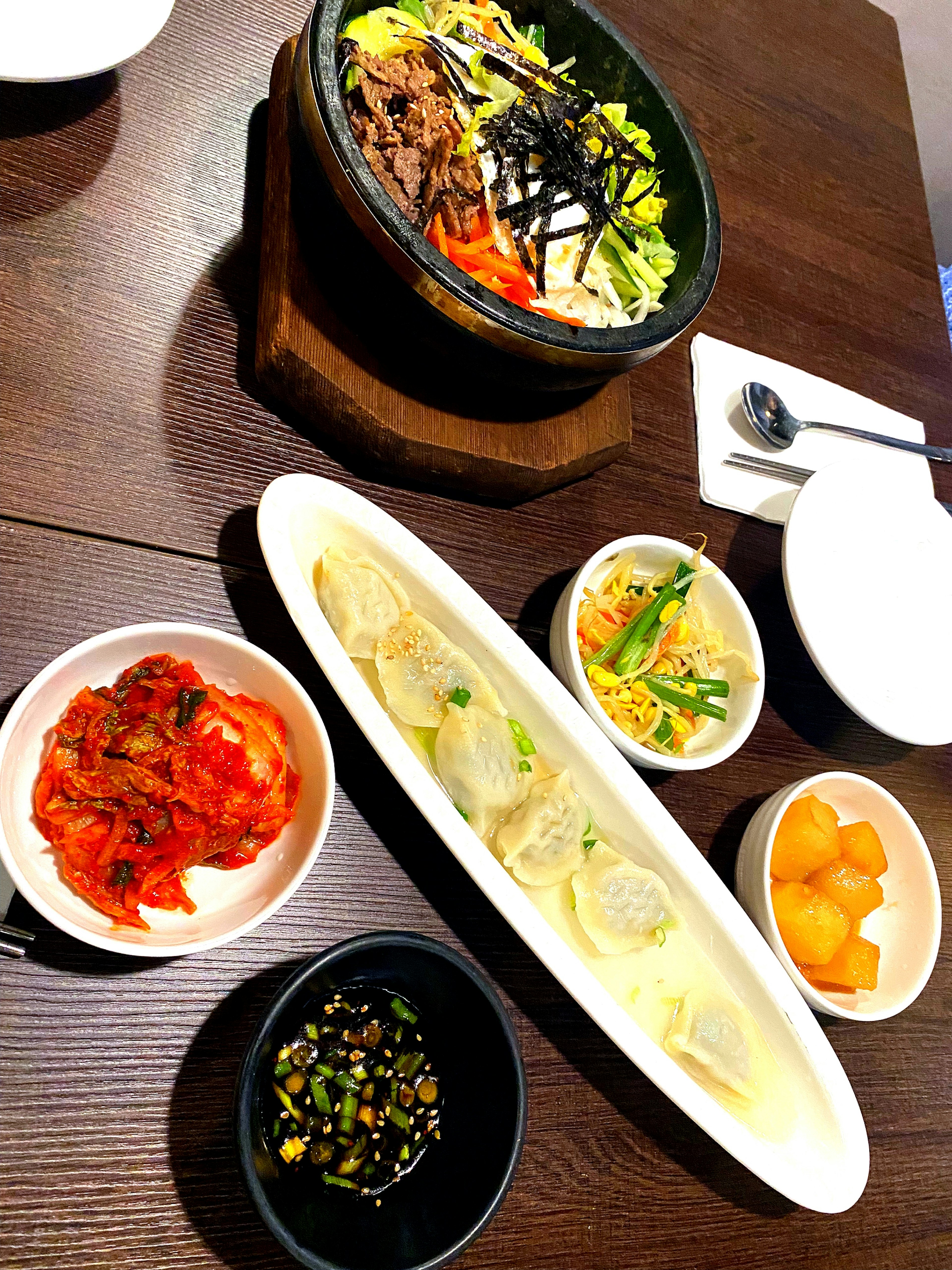 A Korean meal featuring bibimbap and various side dishes