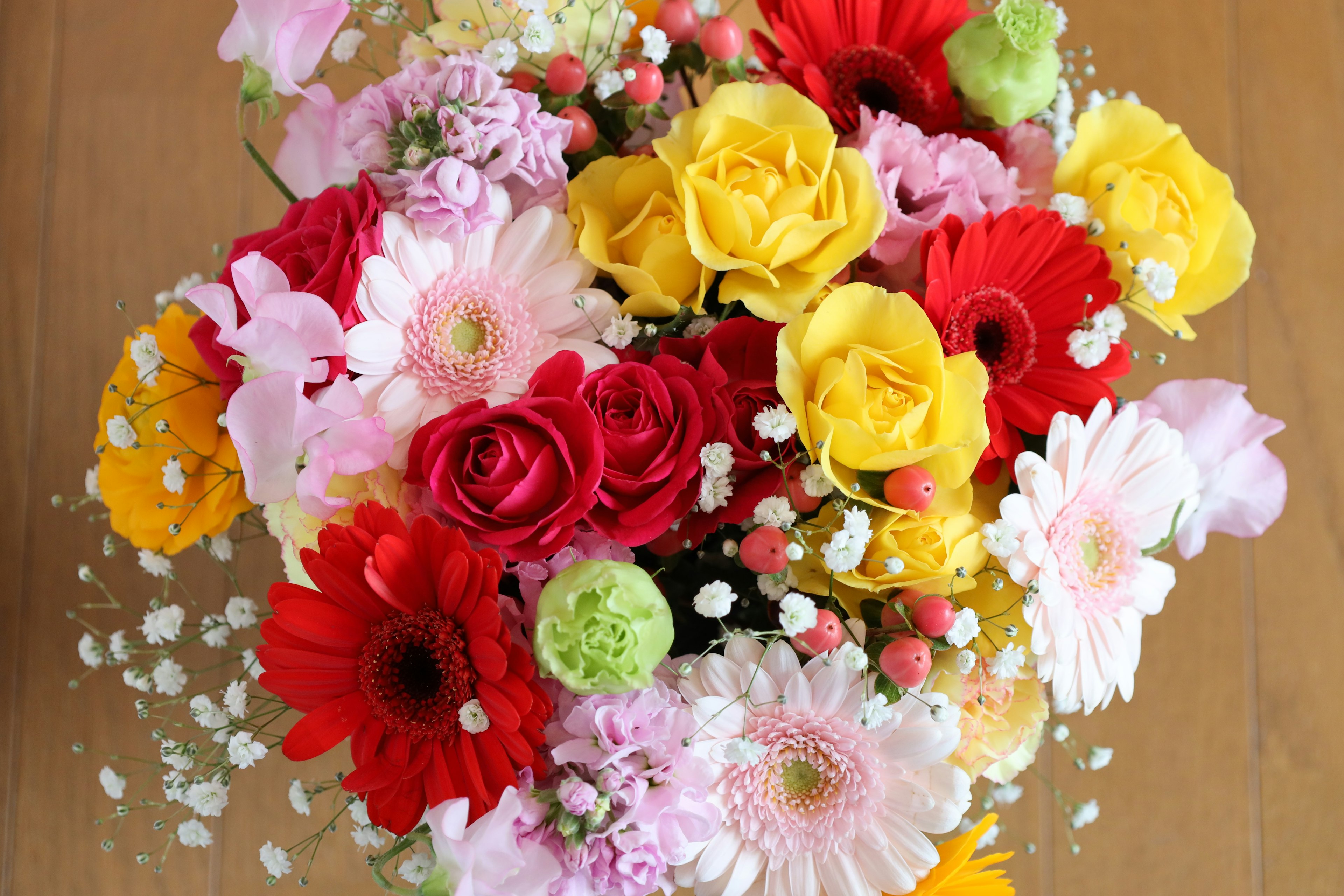 Colorful bouquet featuring red roses yellow roses pink gerberas and white flowers