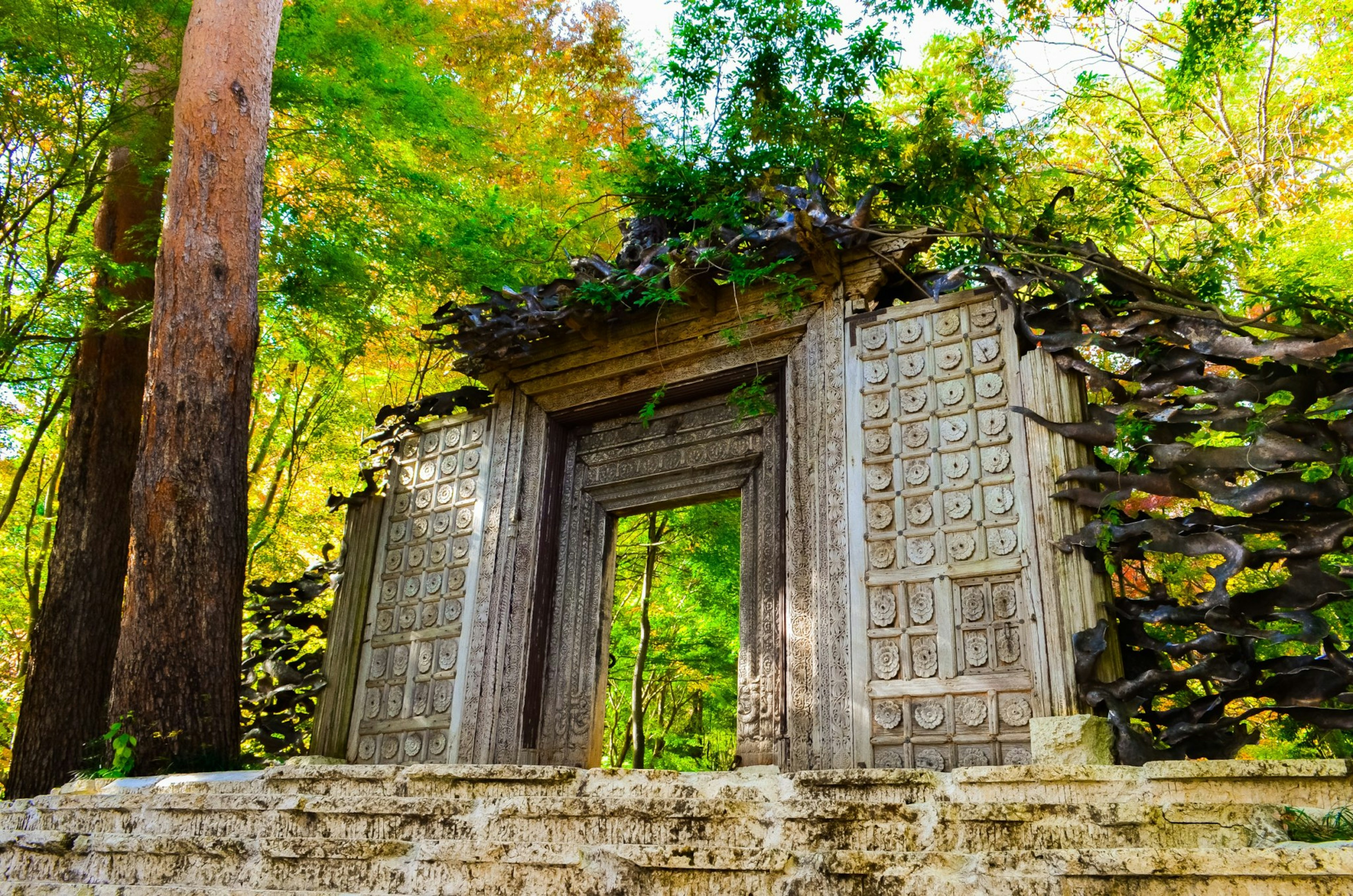 Antigua puerta de piedra rodeada de vegetación exuberante