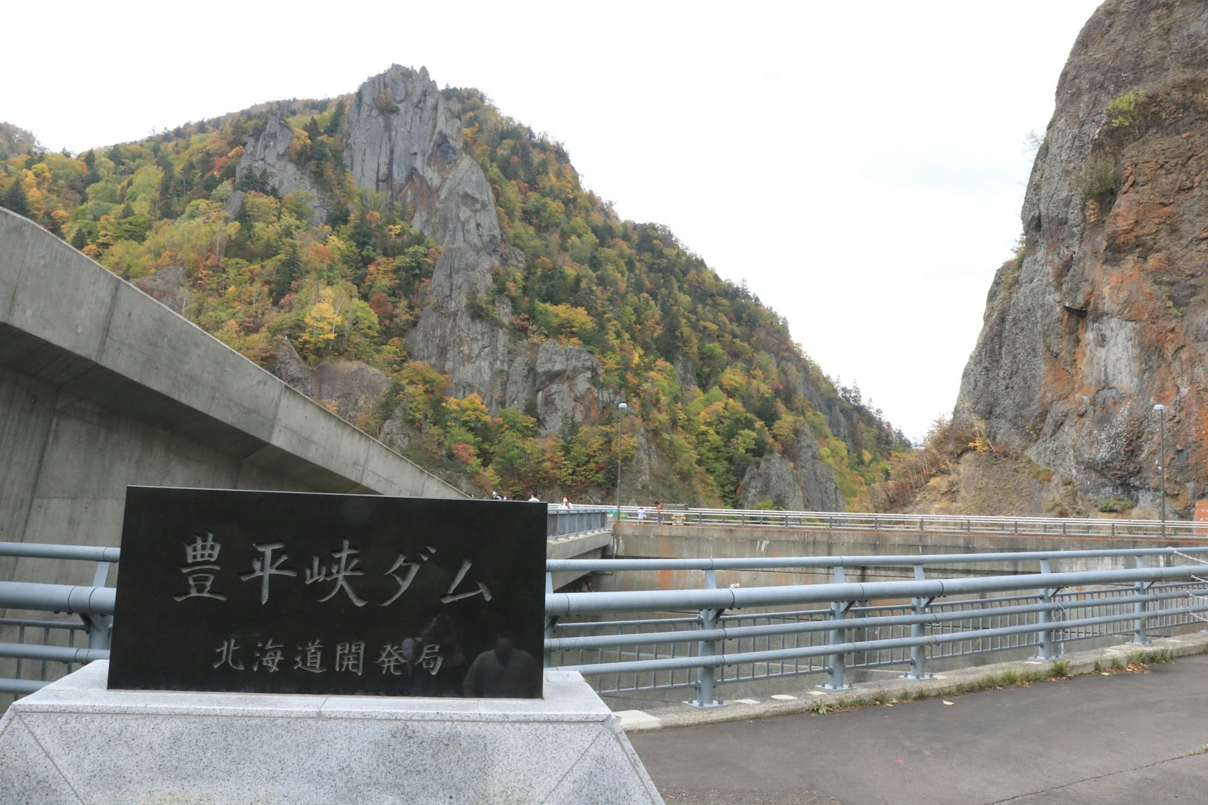 Sign of Hiraokyo Dam with surrounding mountains