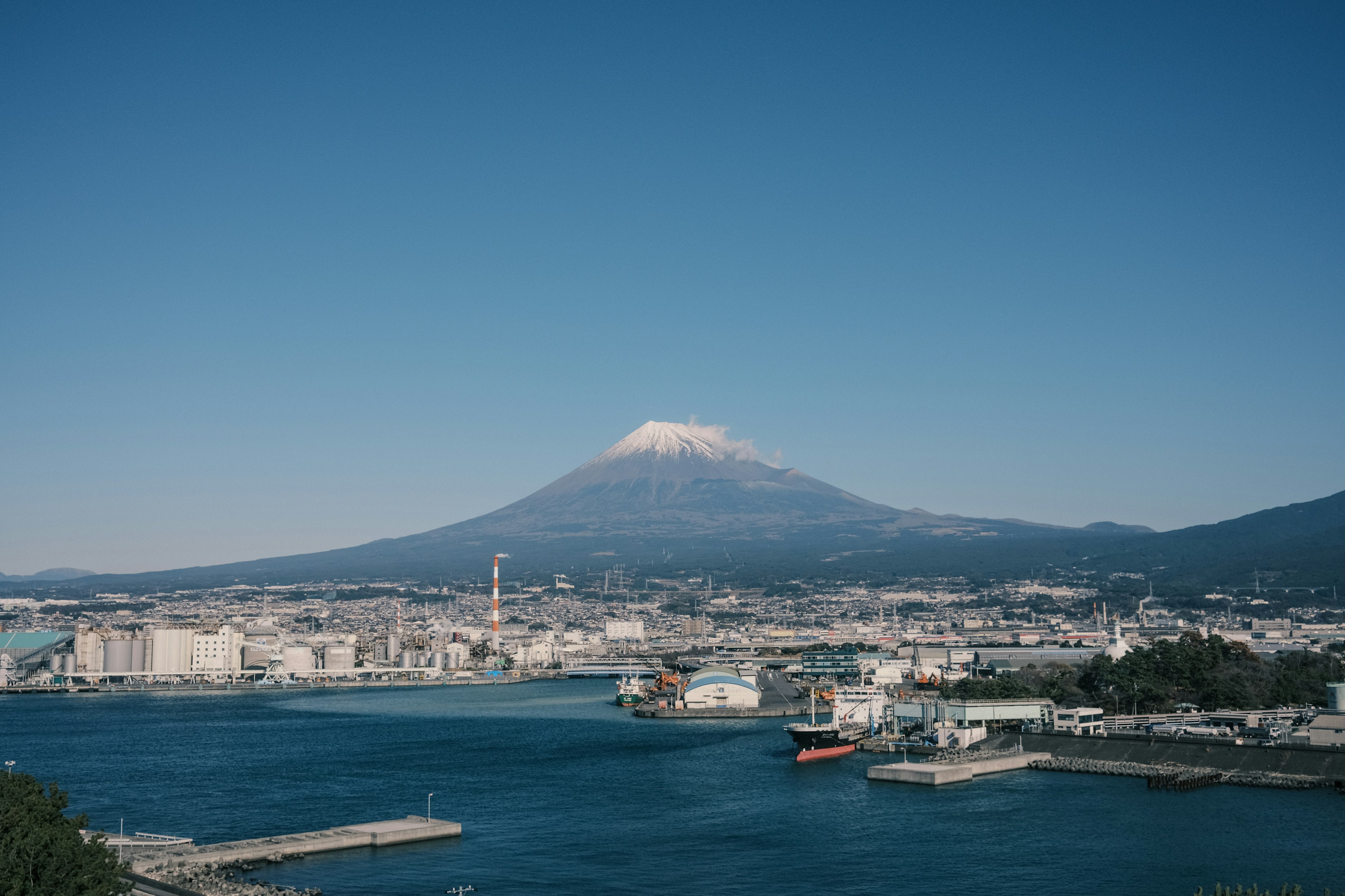 Blick auf den Fuji und die Hafenstadt unter klarem blauen Himmel