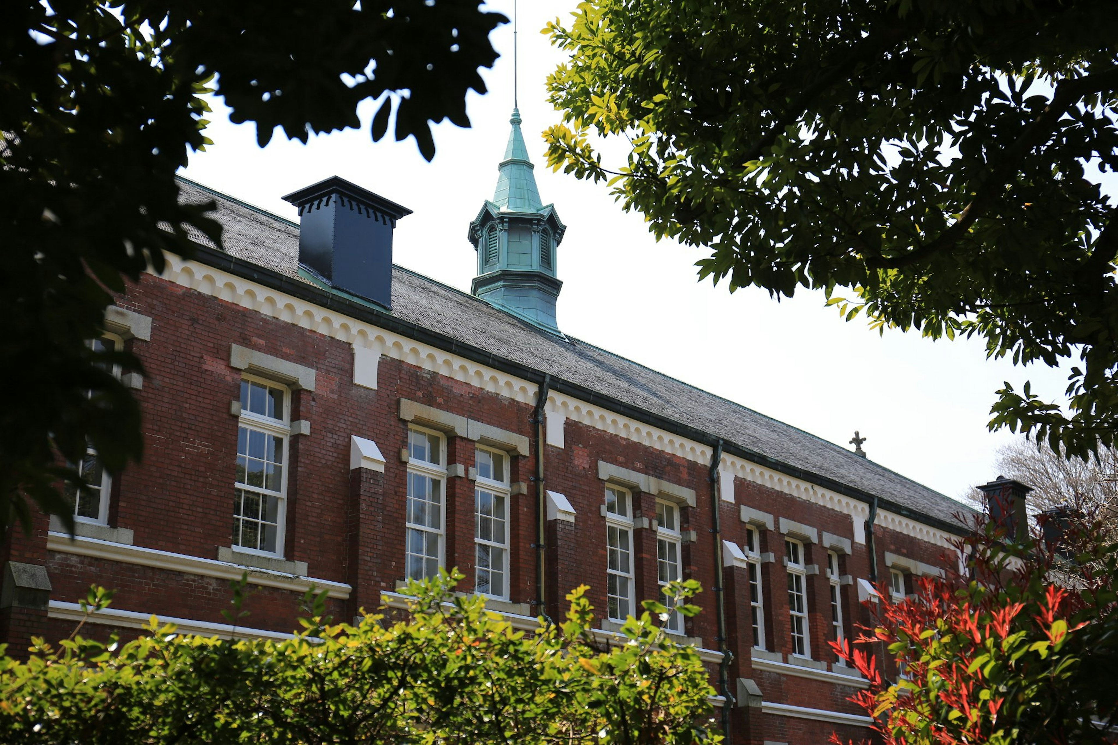 Red brick building with green trees in the foreground