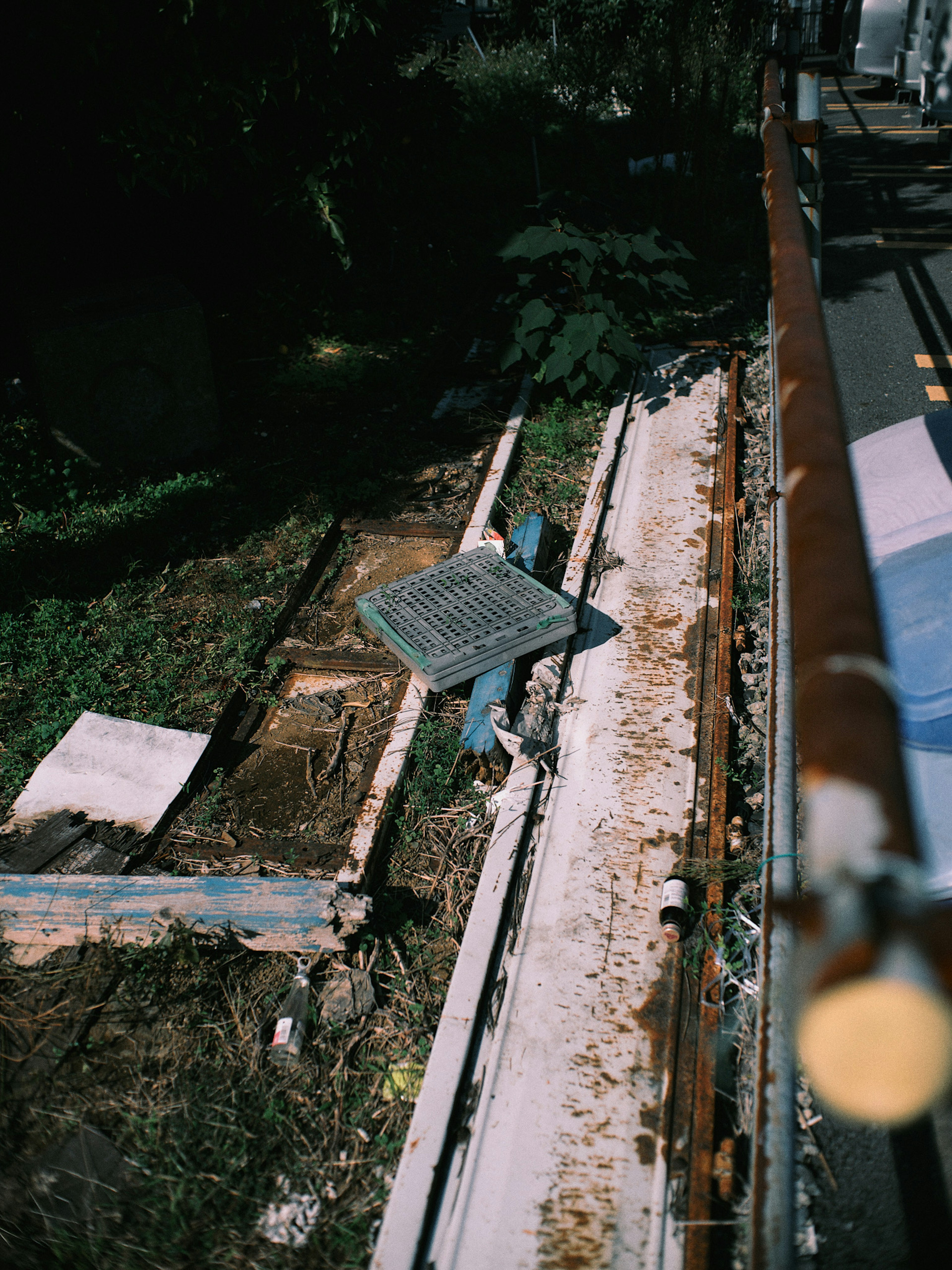 Beschädigte Gleise an einer Baustelle mit grünem Gras