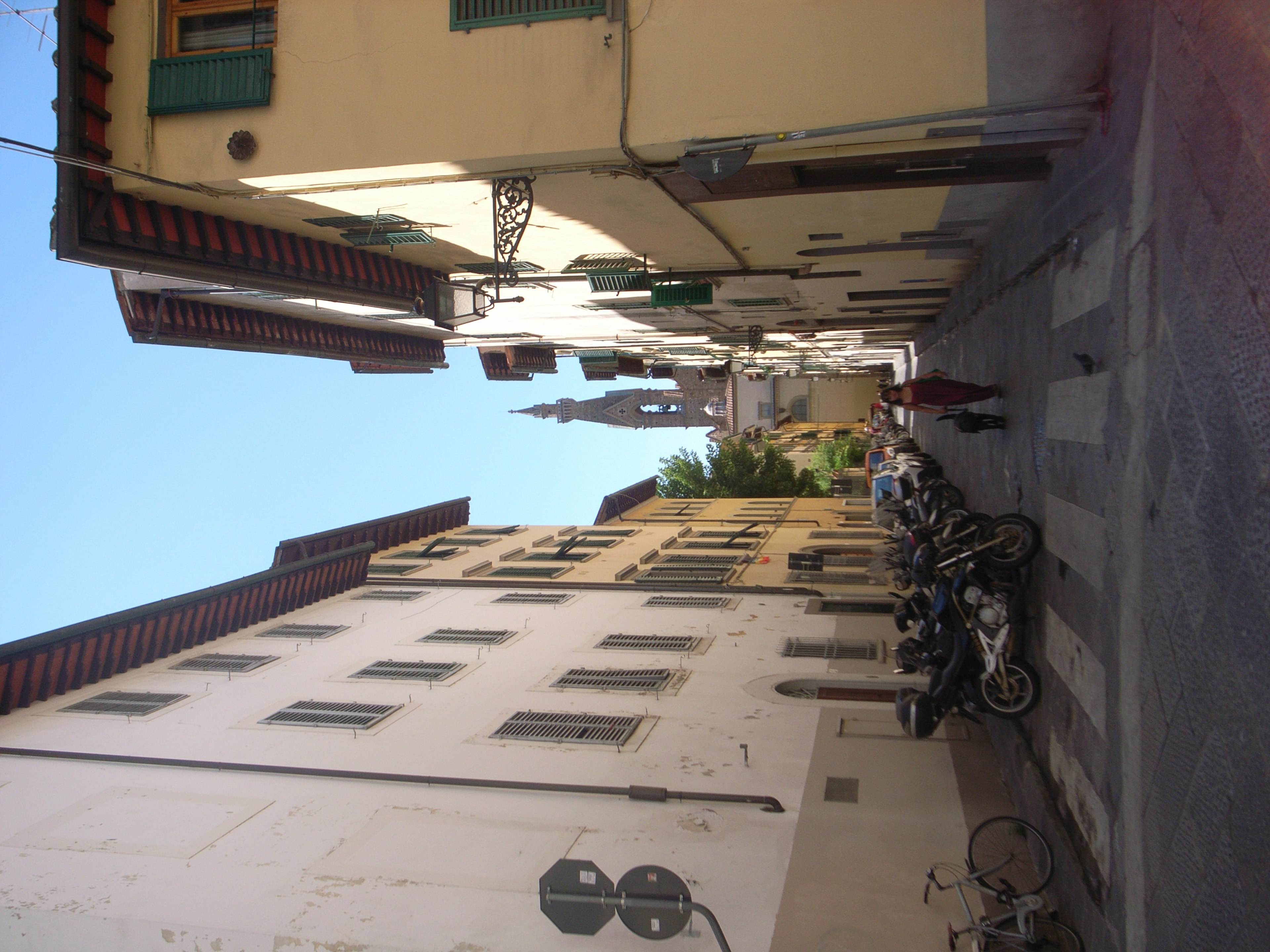 Rue tranquille à Florence avec des motos garées et des bâtiments historiques