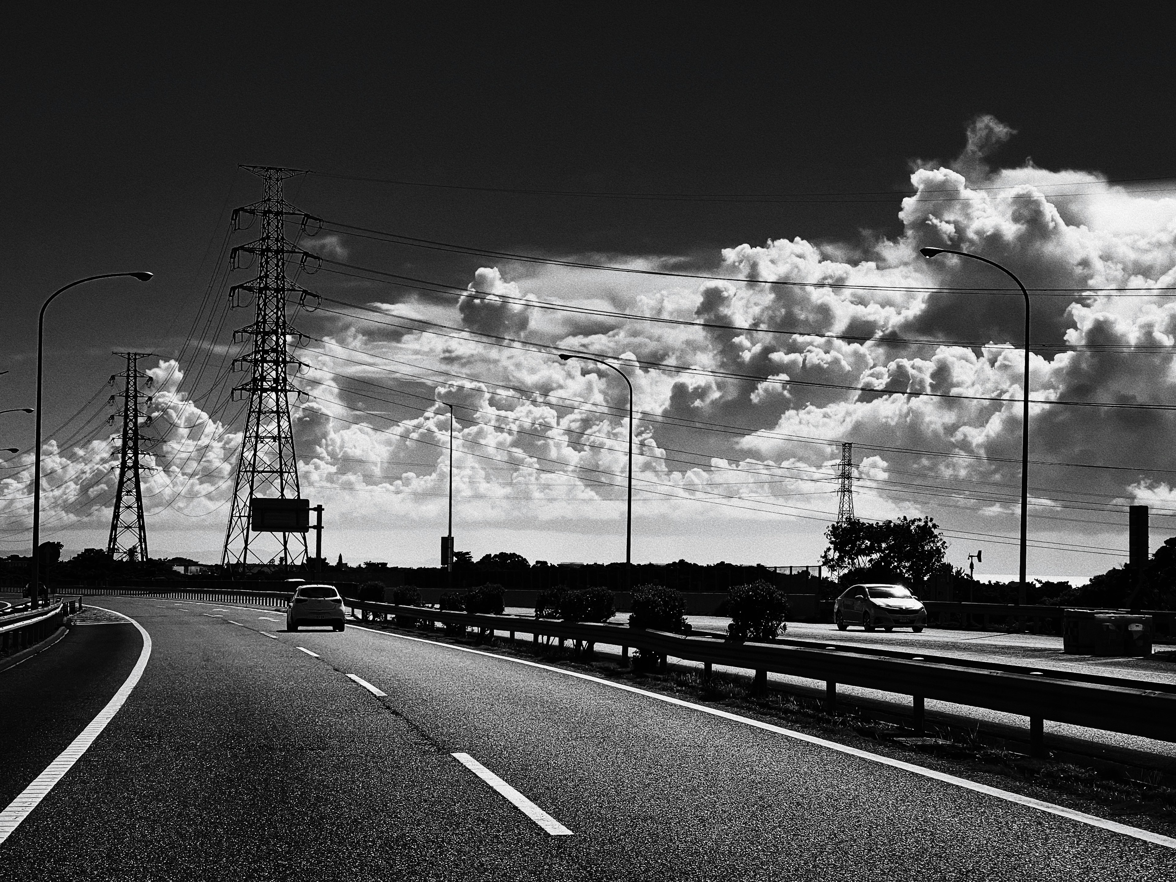 Autoroute en noir et blanc avec des nuages dans le ciel