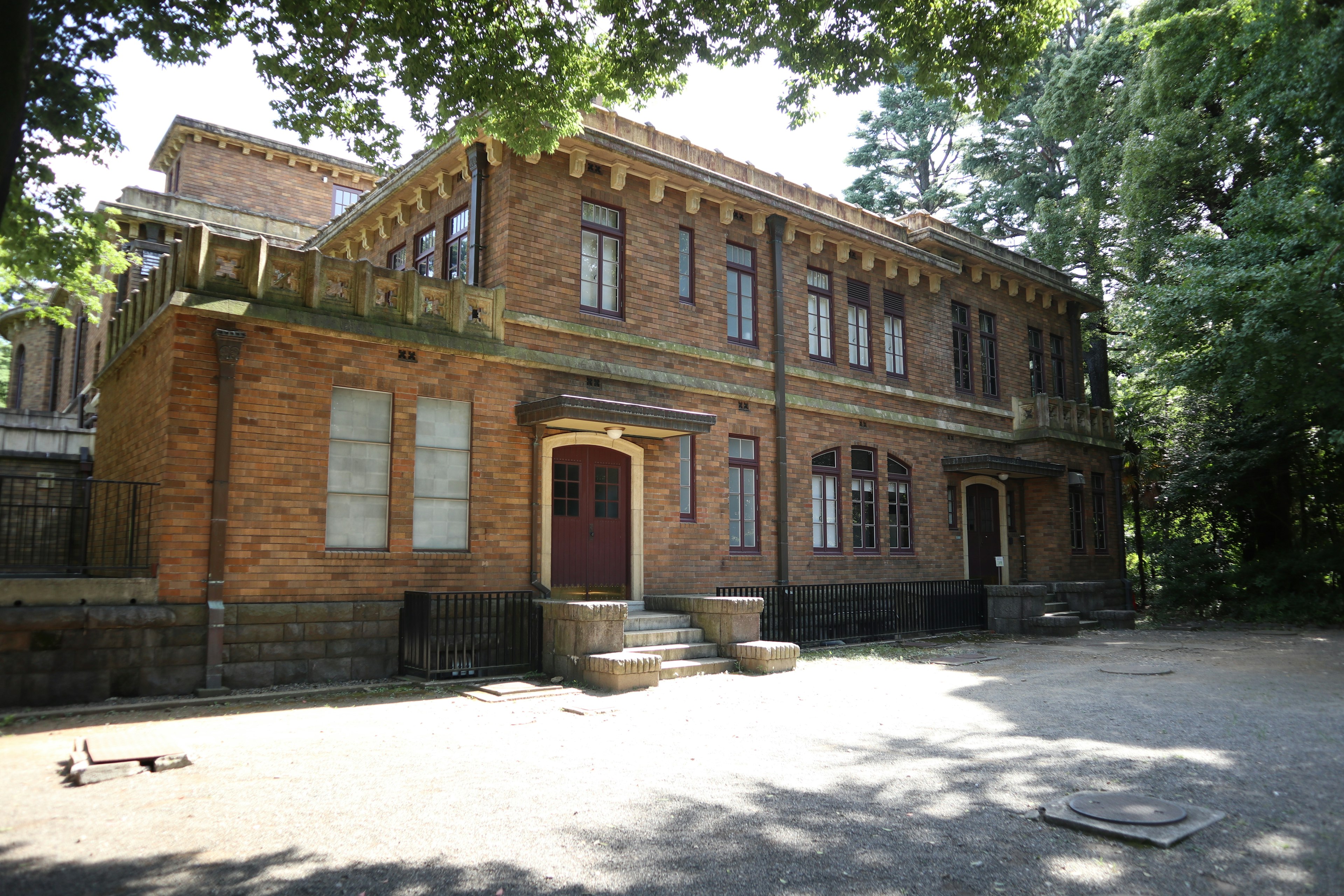 Old brick building surrounded by green trees