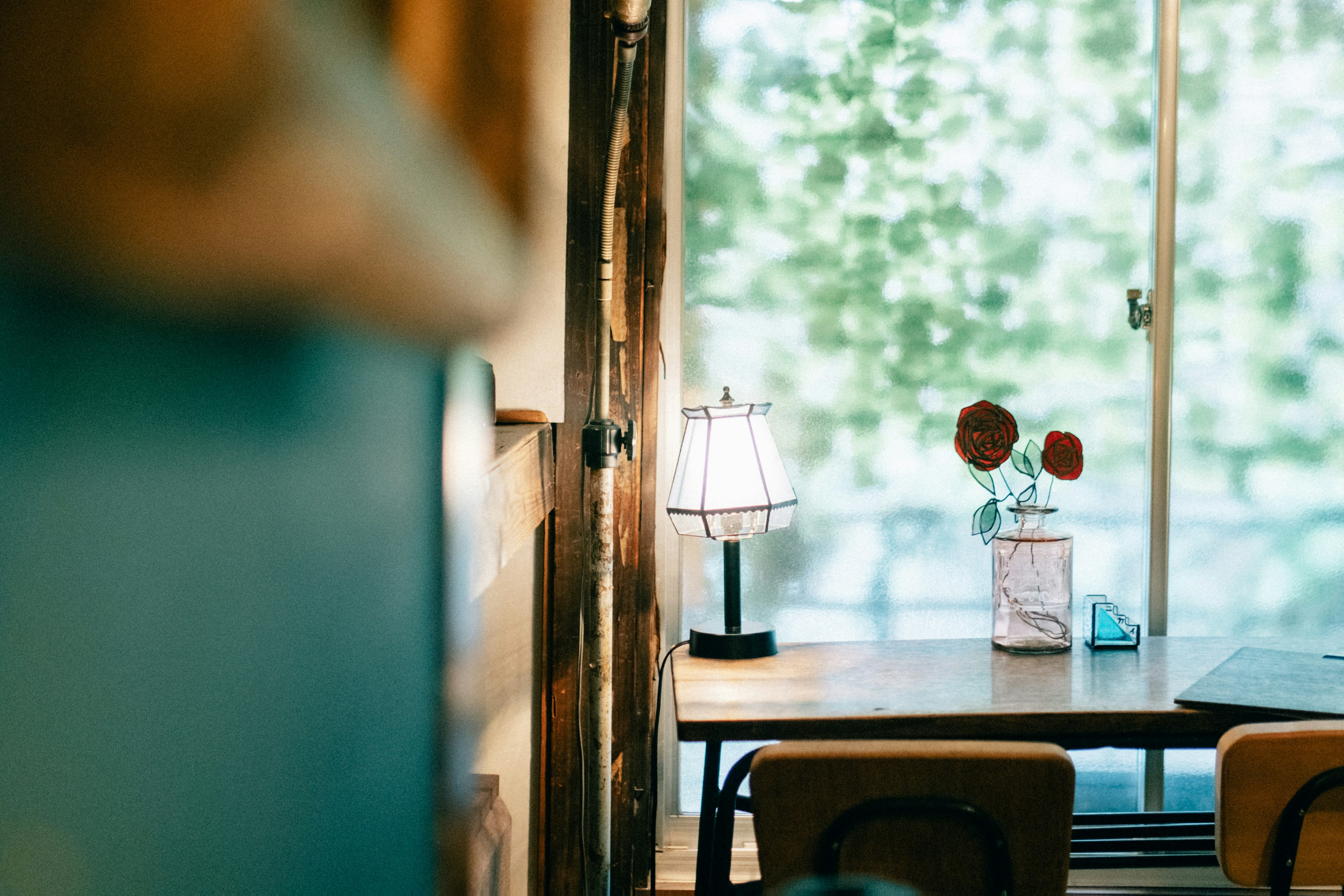 Cozy cafe interior with a table near the window and a vase of flowers