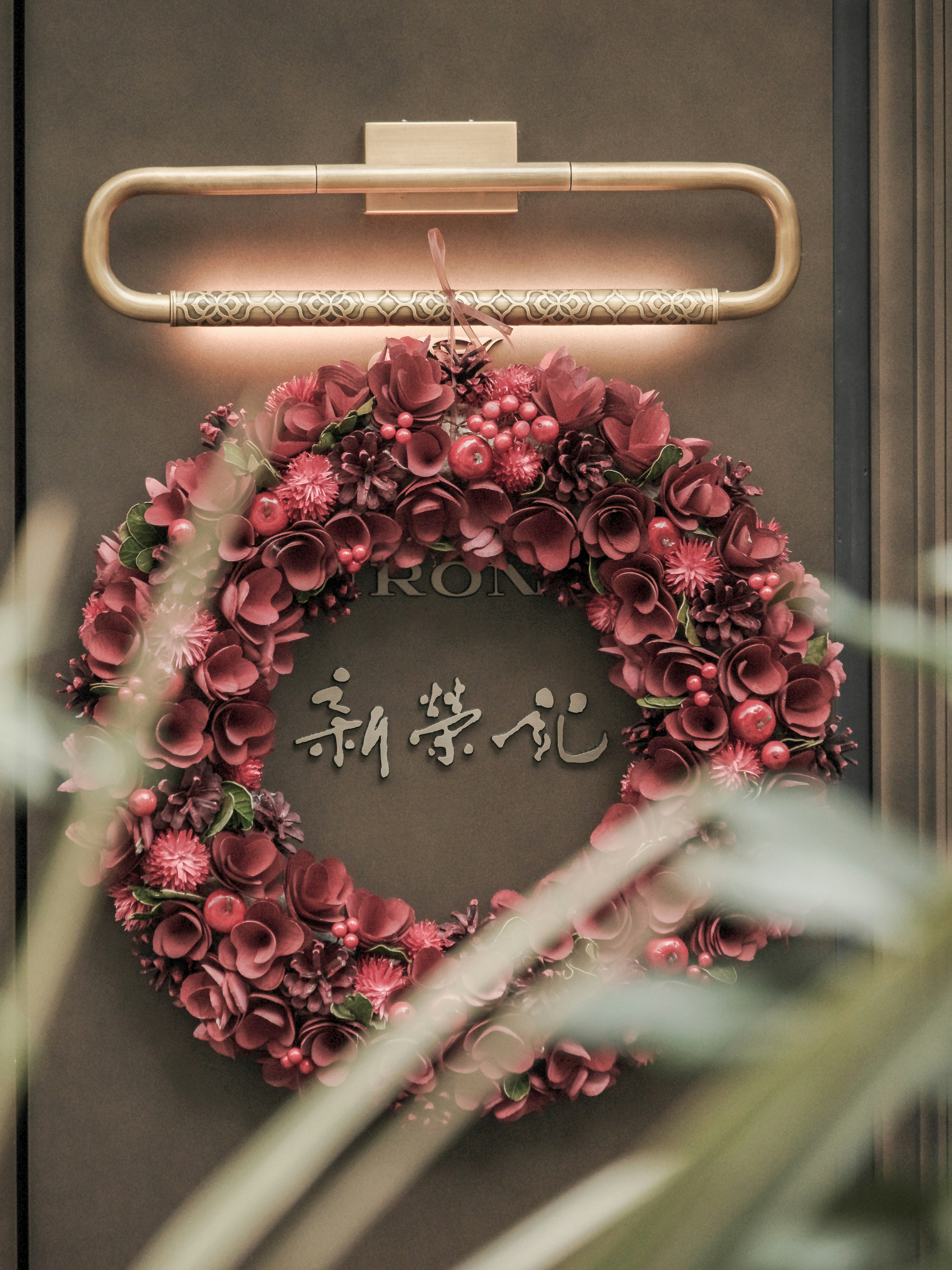 Pink floral wreath on a door with elegant lighting