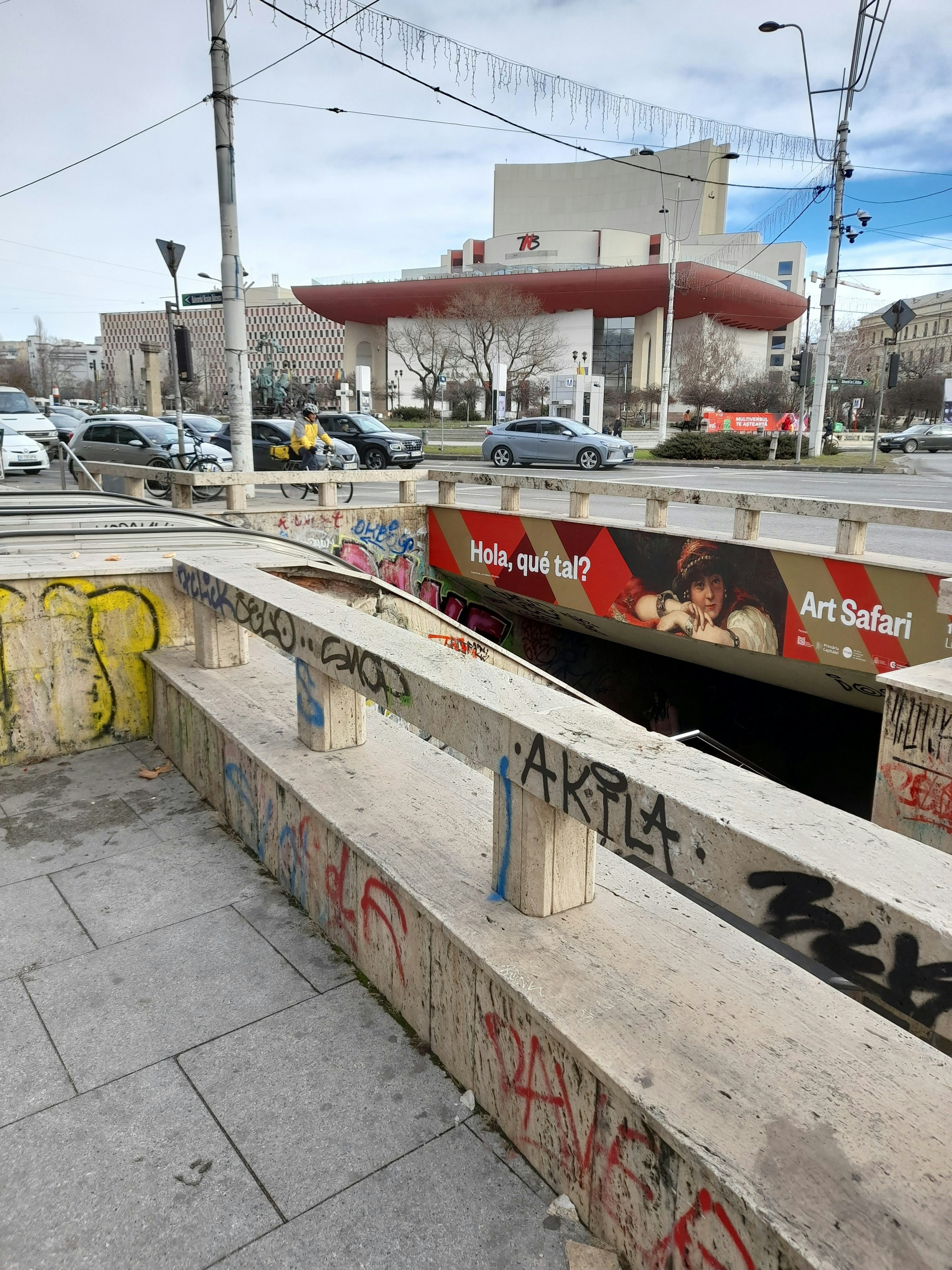 Entrance to an underground passage with a modern building in the background