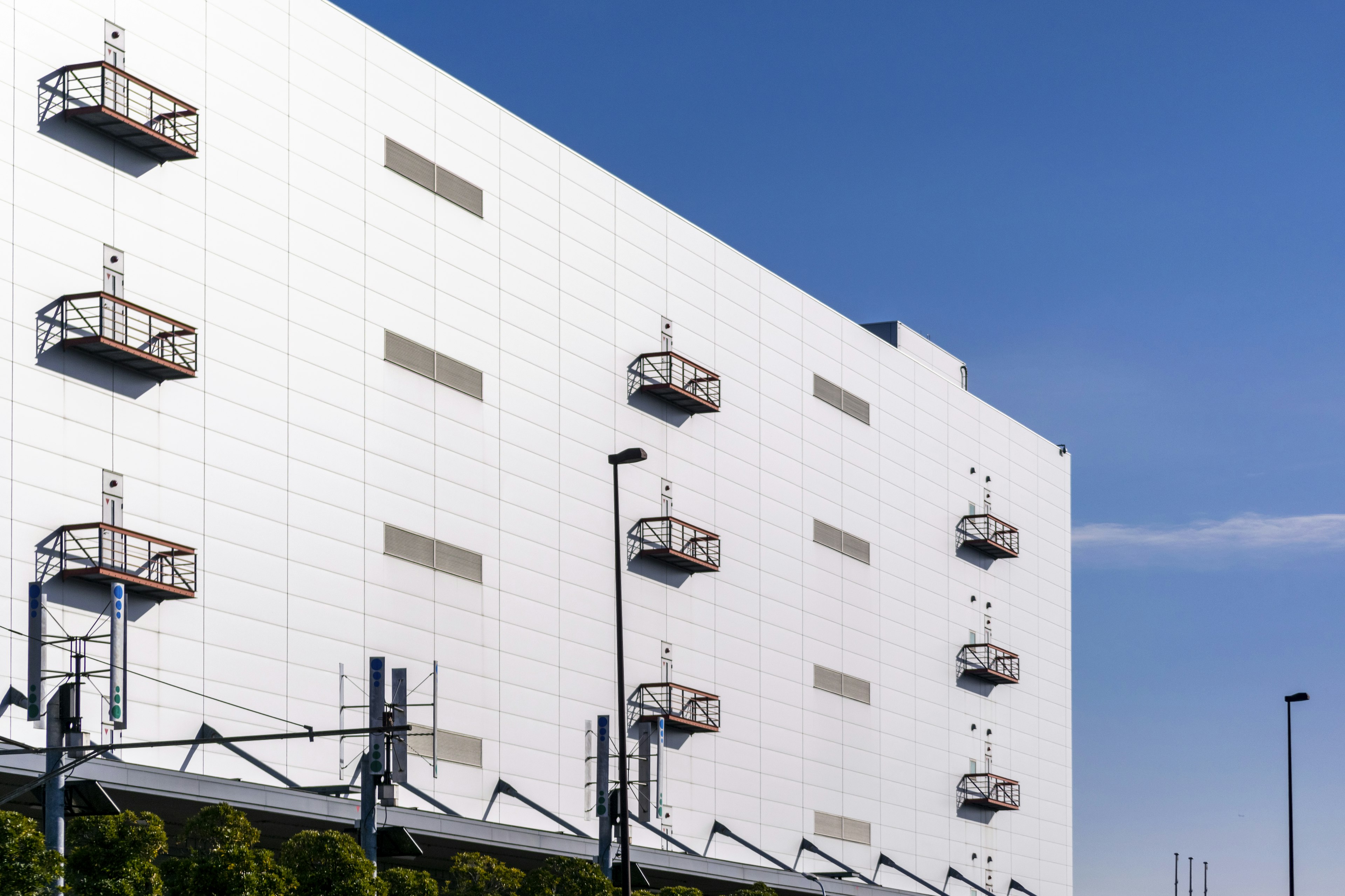 White building exterior with balconies and blue sky