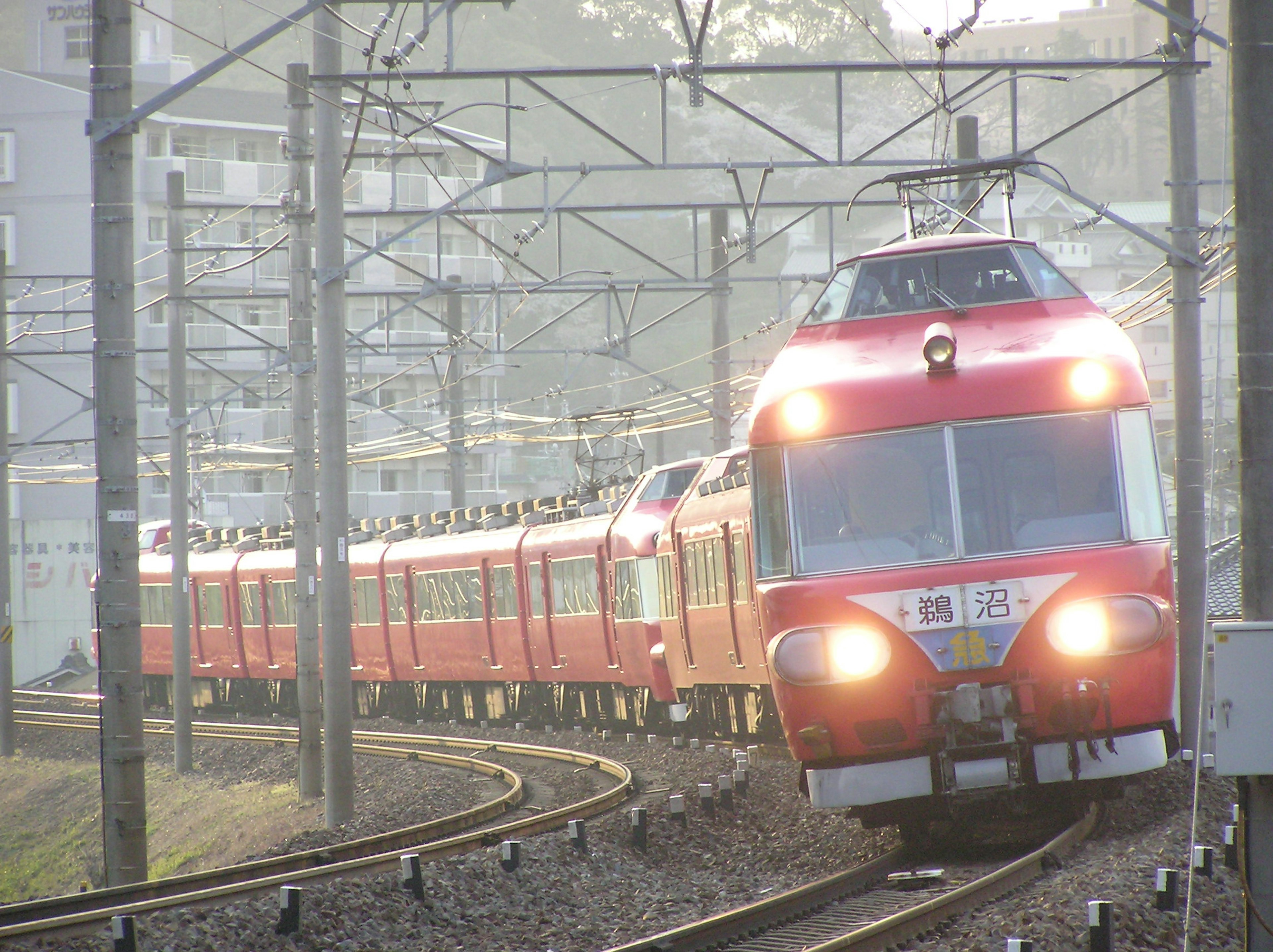 Train rouge tournant dans un virage sur la voie ferrée