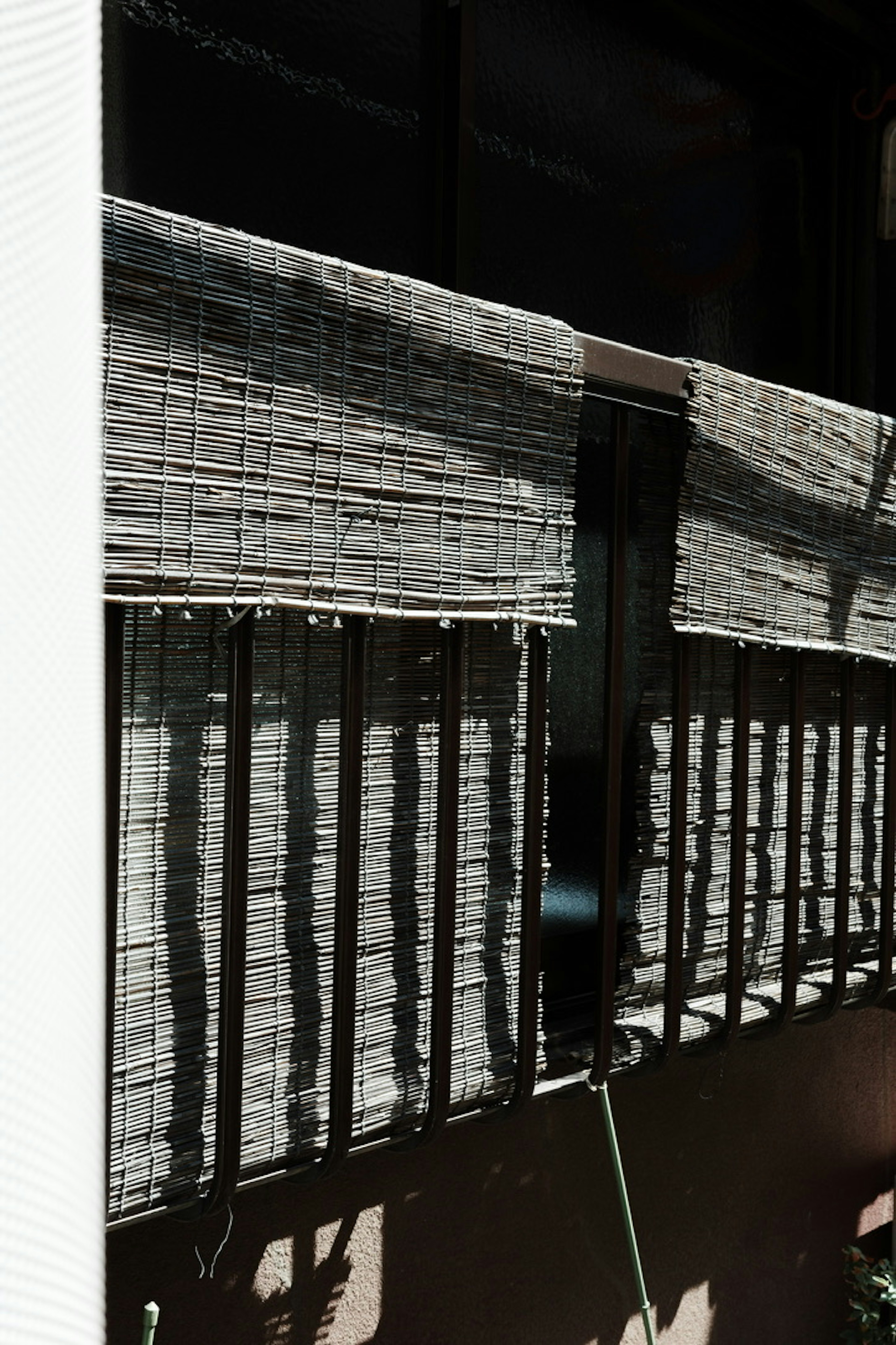 Sunlit balcony railing with curtain shadows