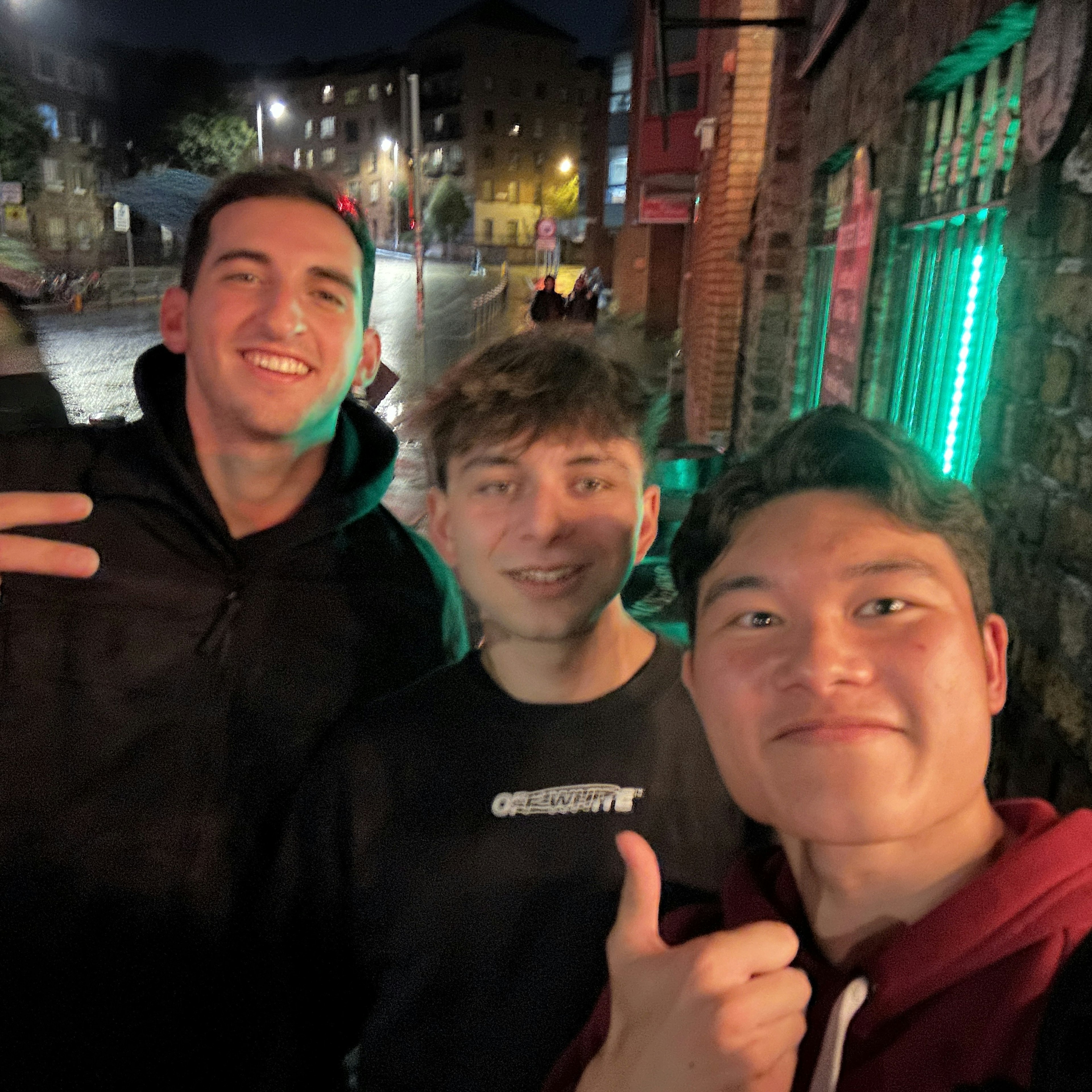 Trois amis prenant un selfie la nuit dans un cadre urbain