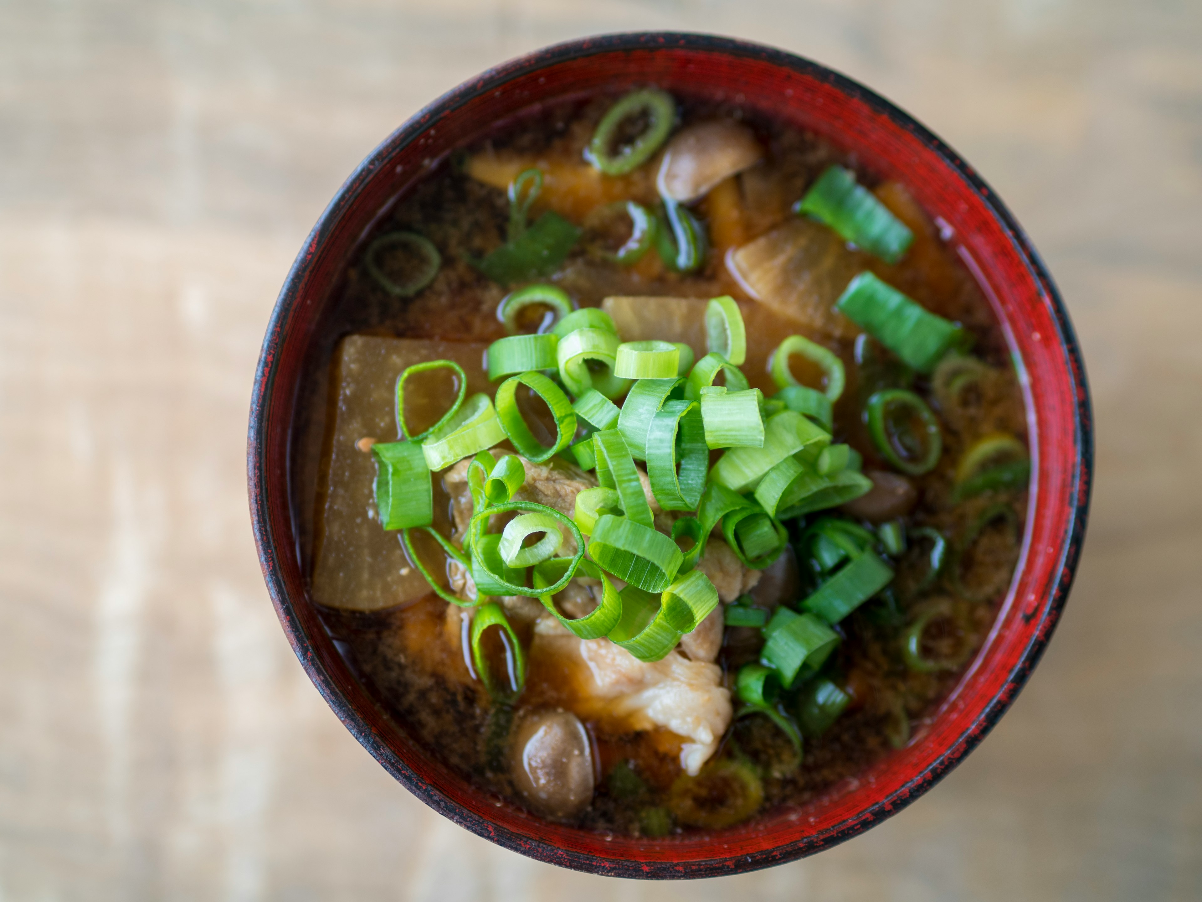 Vista superior de sopa de miso con cebollas verdes y champiñones