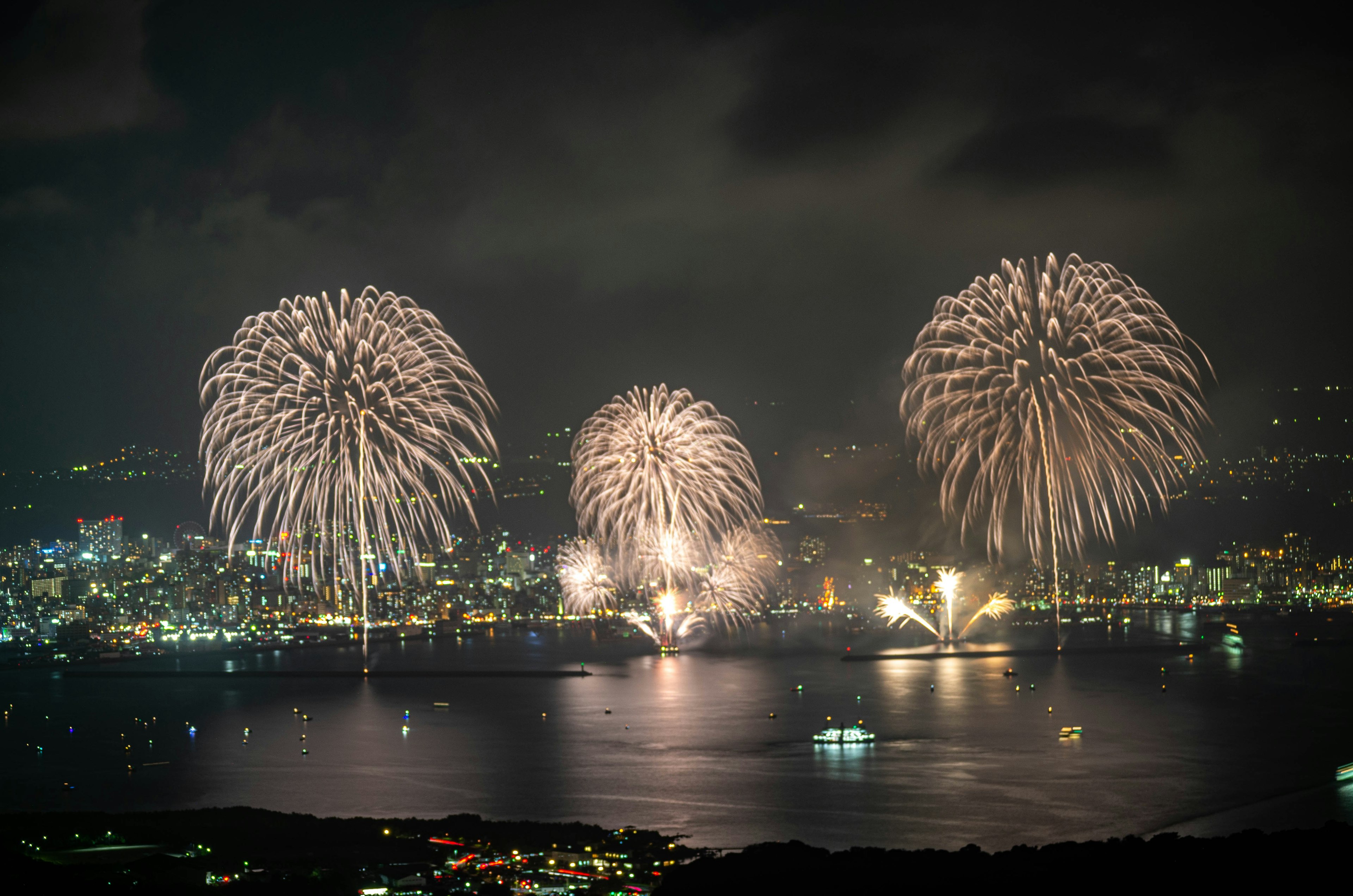 Feux d'artifice illuminant le ciel nocturne au-dessus d'un front de mer pittoresque