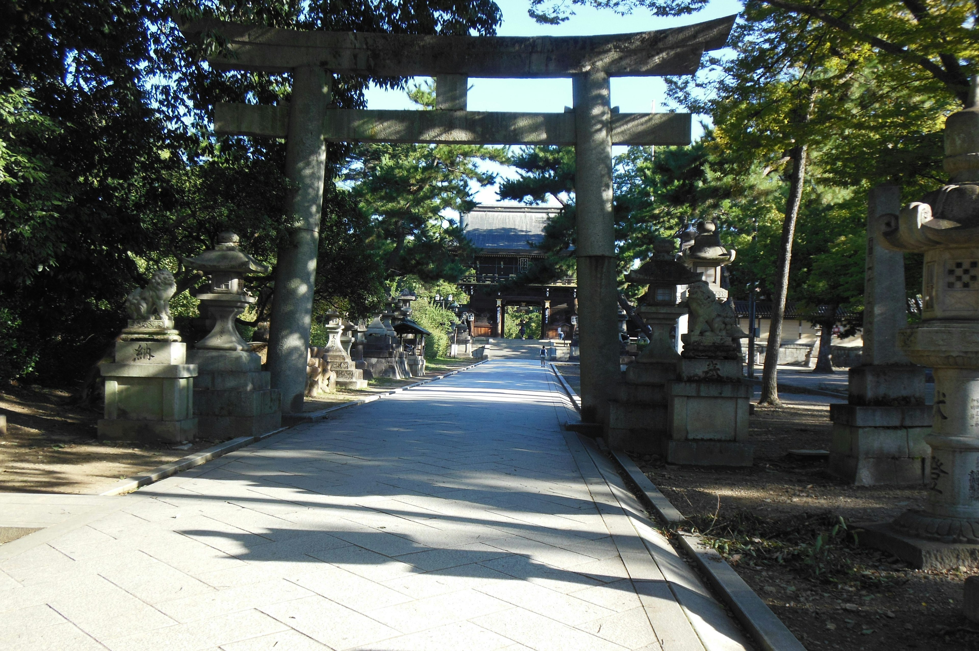 Pathway leading to a shrine with a torii gate and stone statues