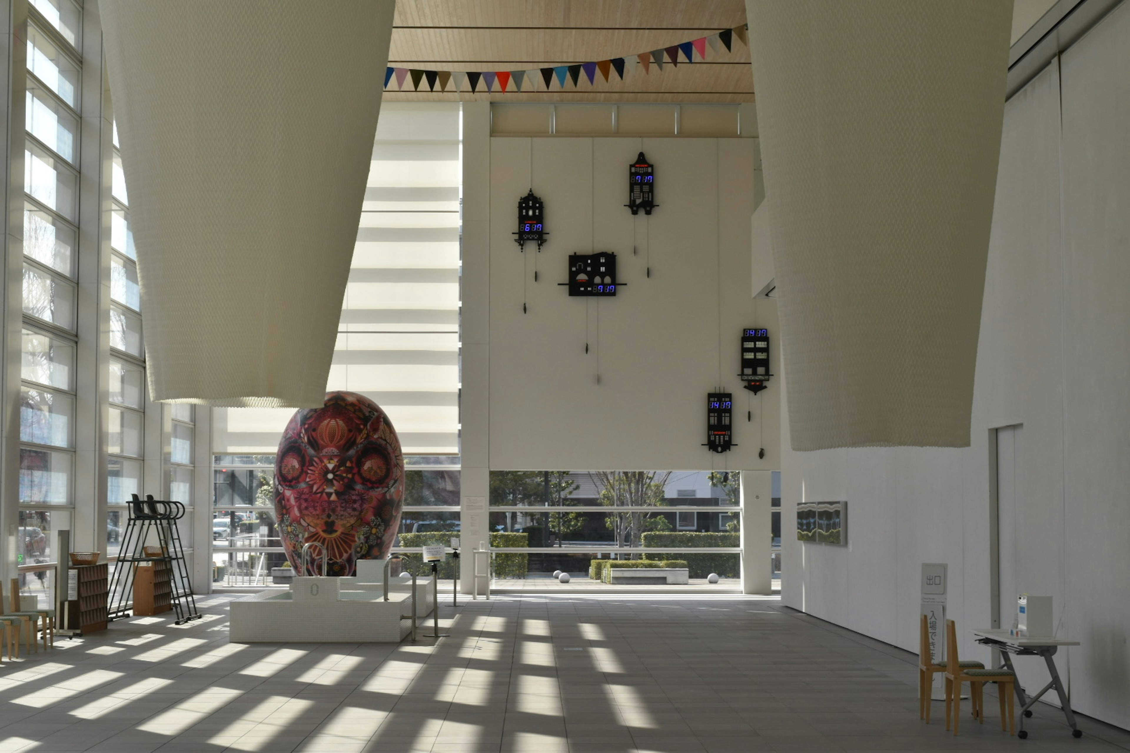 Spacious interior of a modern art gallery featuring a large sculpture and decorative elements