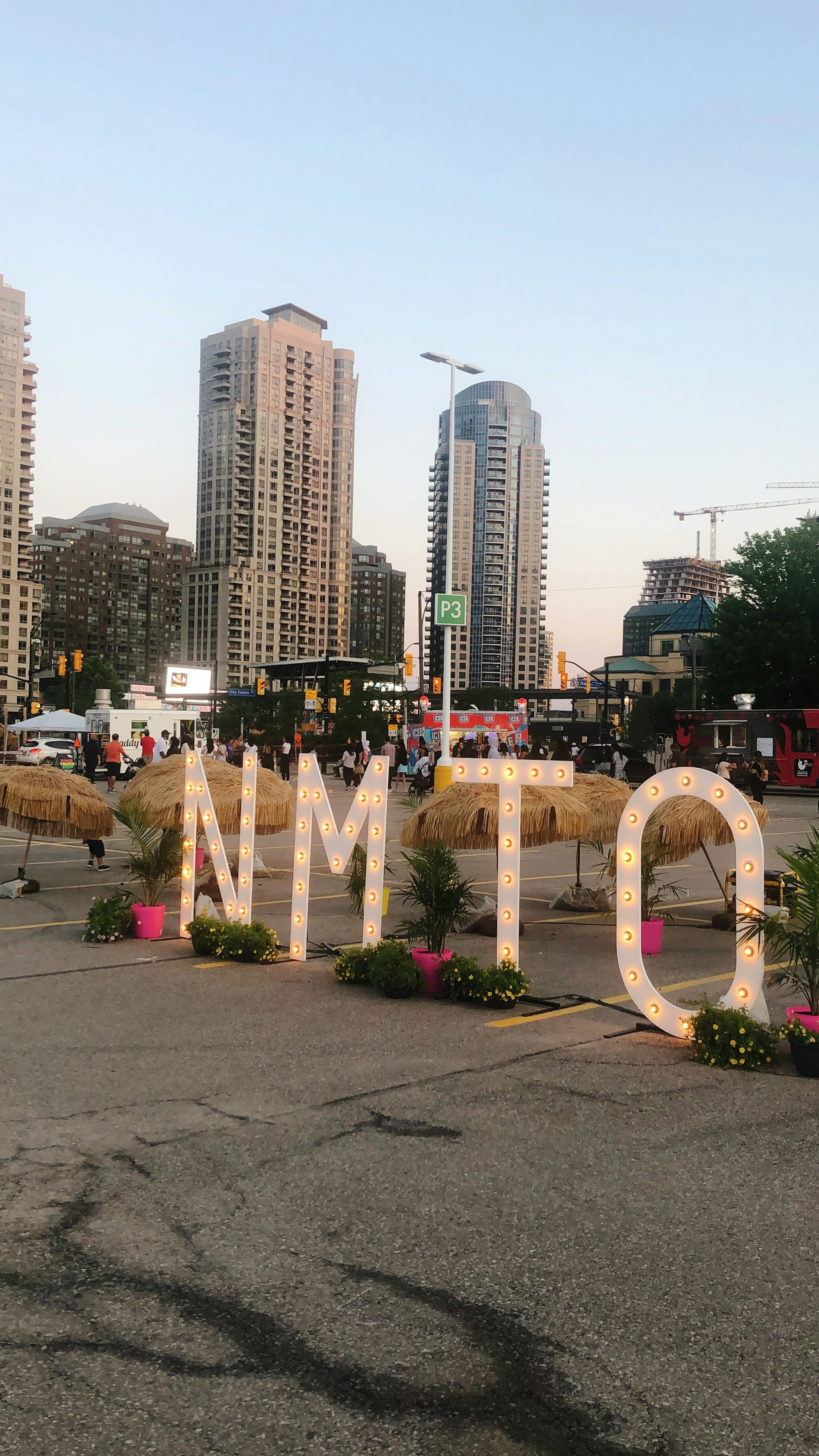 Urban scene with large NMTO letters and surrounding flowers