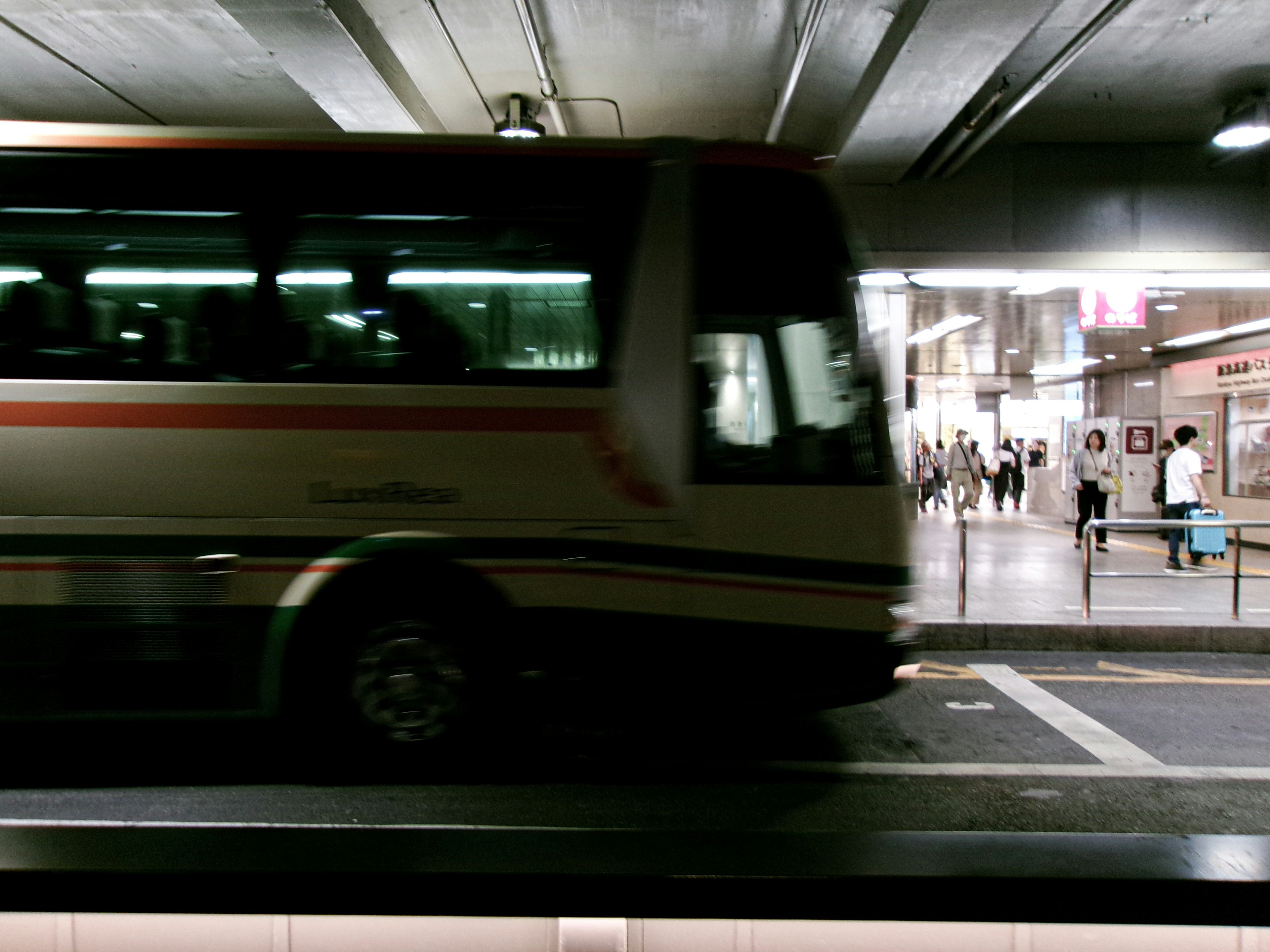 動いているバスと駅の背景が映った都市の風景