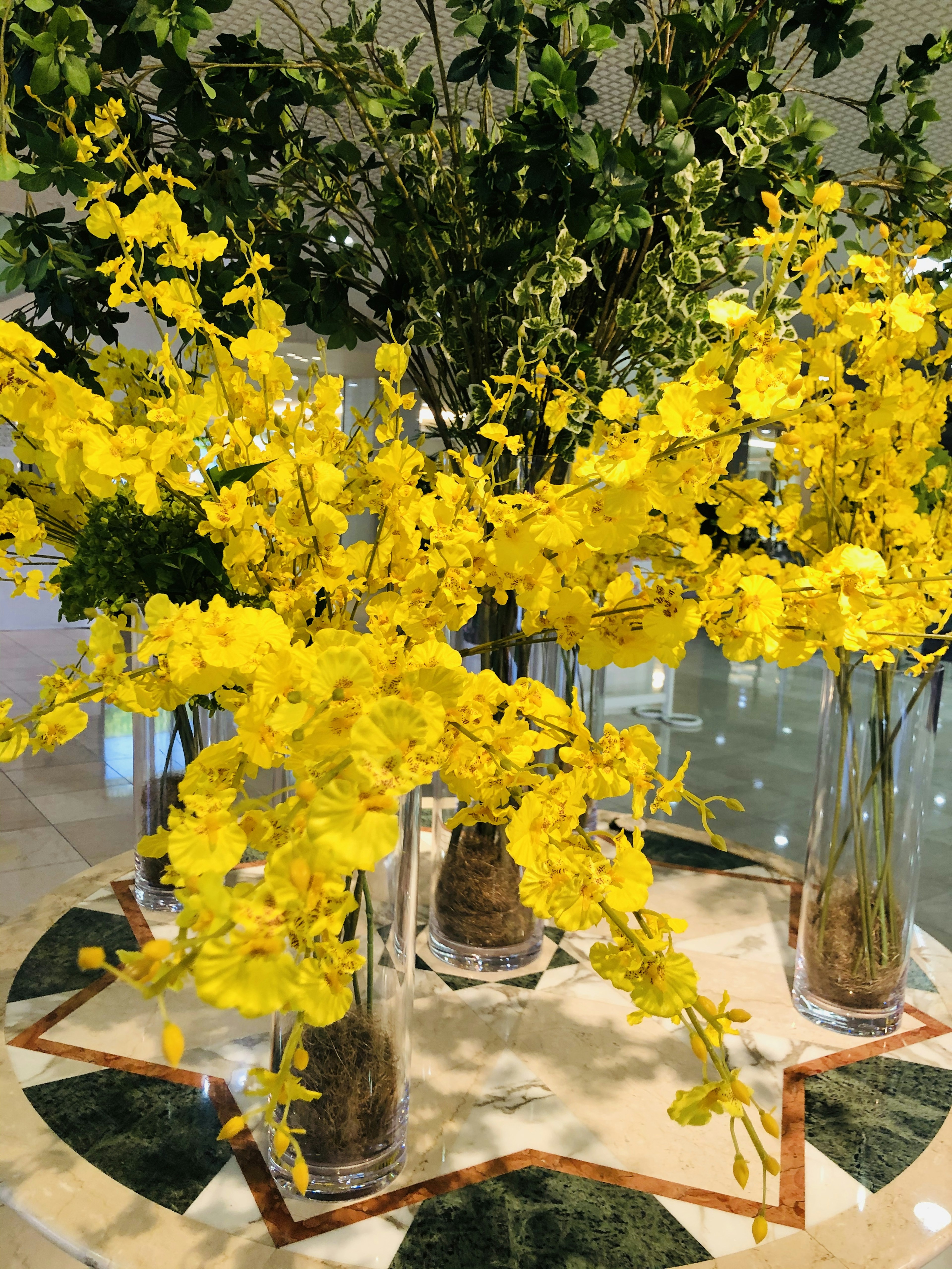 Mesa decorativa con jarrones transparentes llenos de flores amarillas