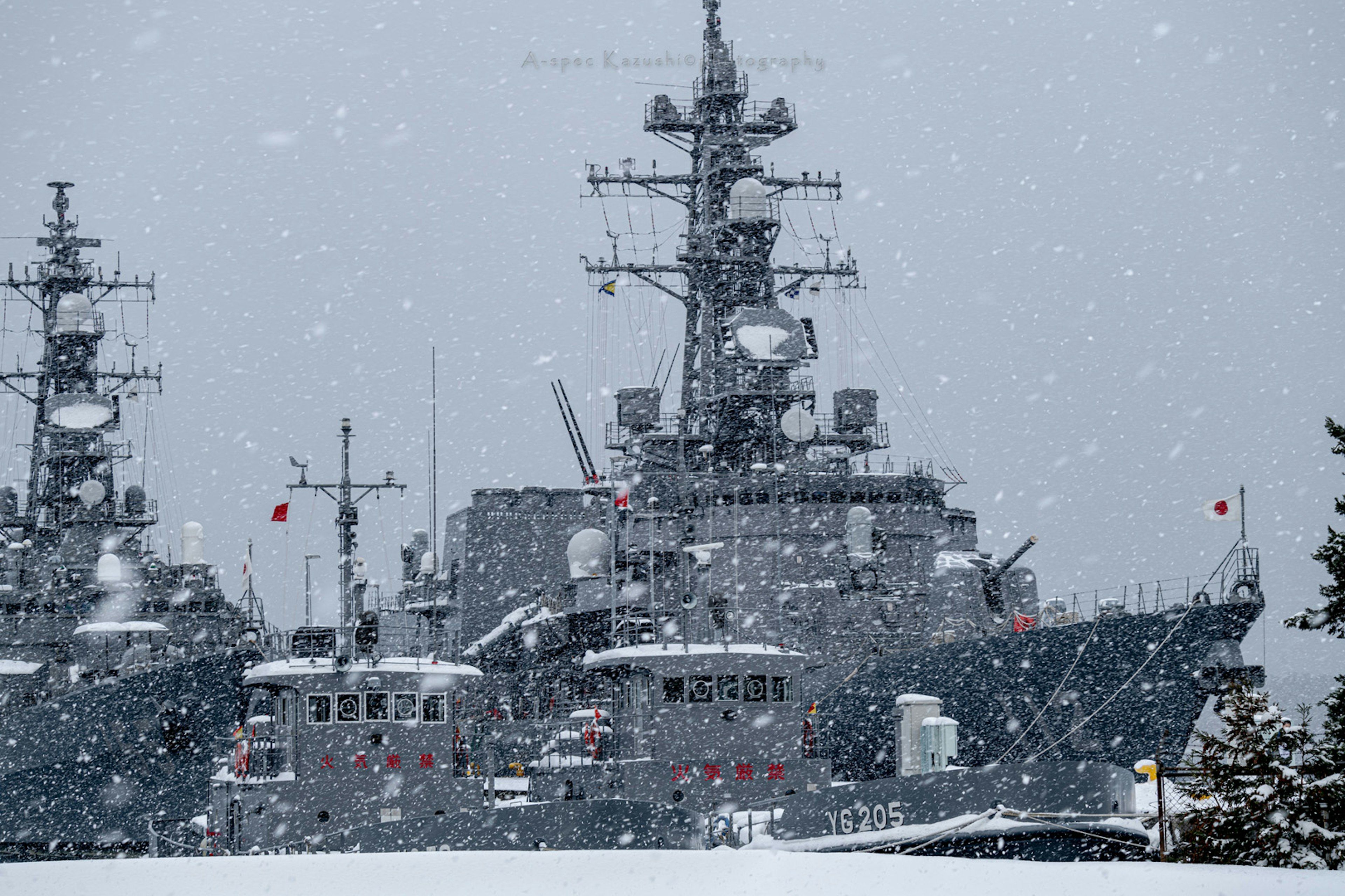 Fleet of naval ships docked in snowy weather