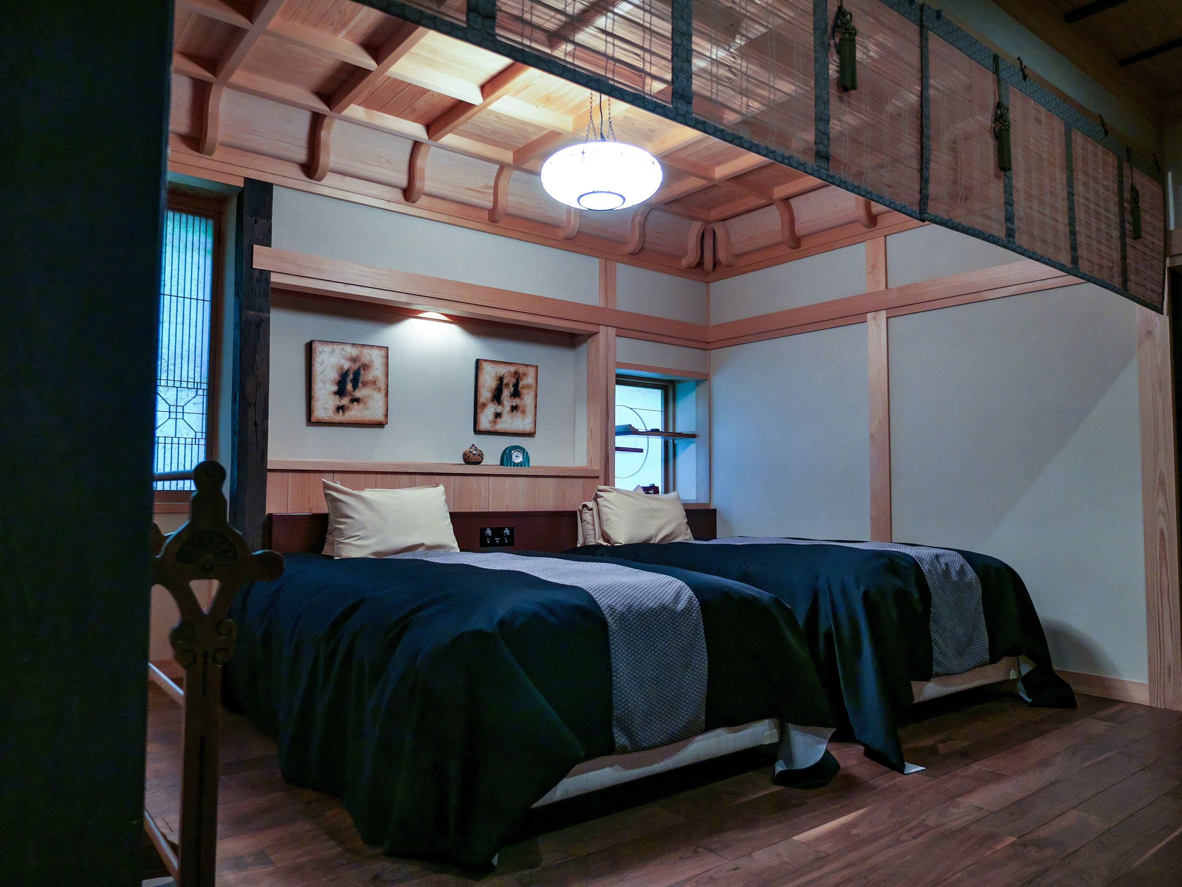 Chambre moderne de style japonais avec deux lits plafond en bois et palette de couleurs apaisantes