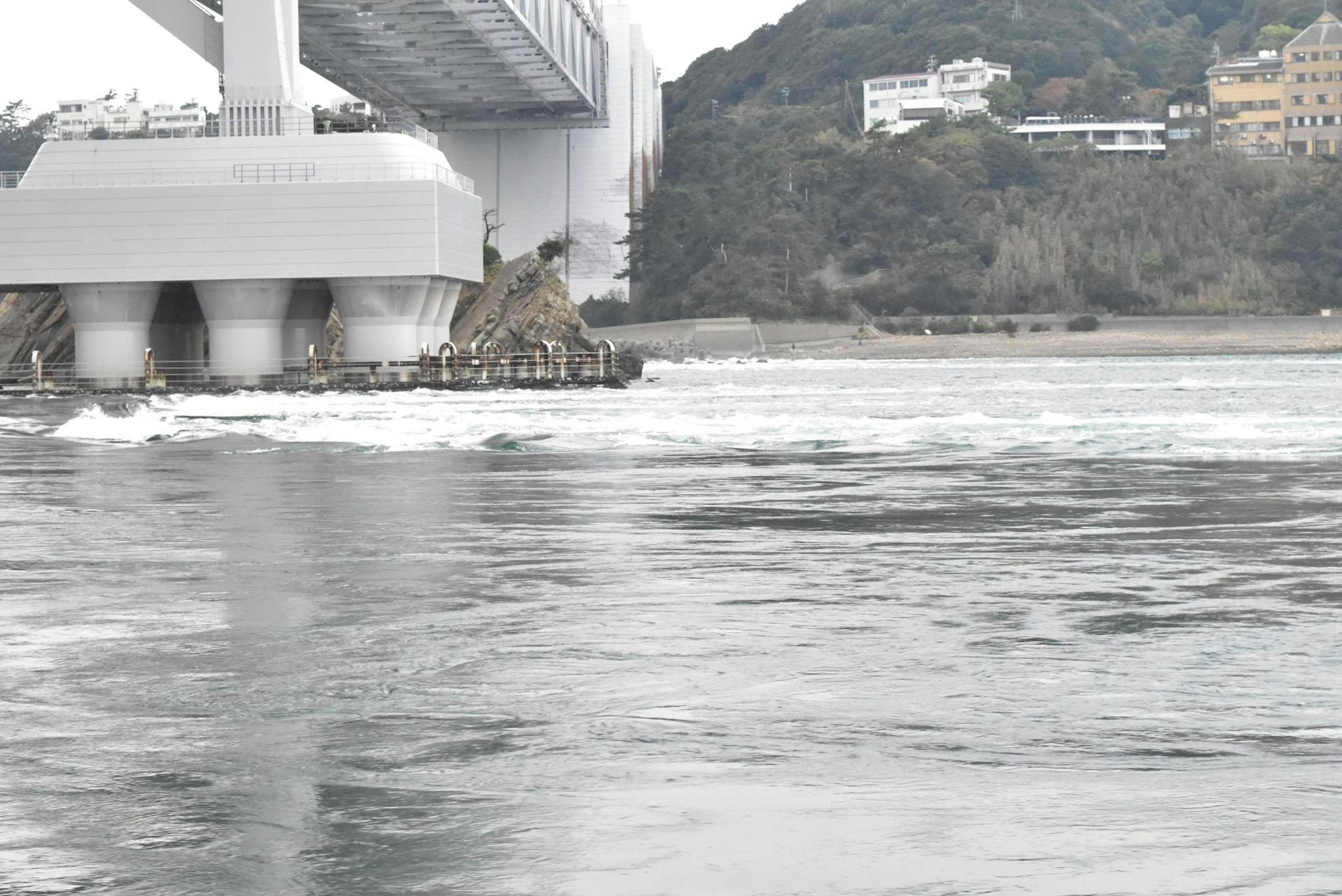 Agua fluyendo debajo de un puente con paisaje circundante