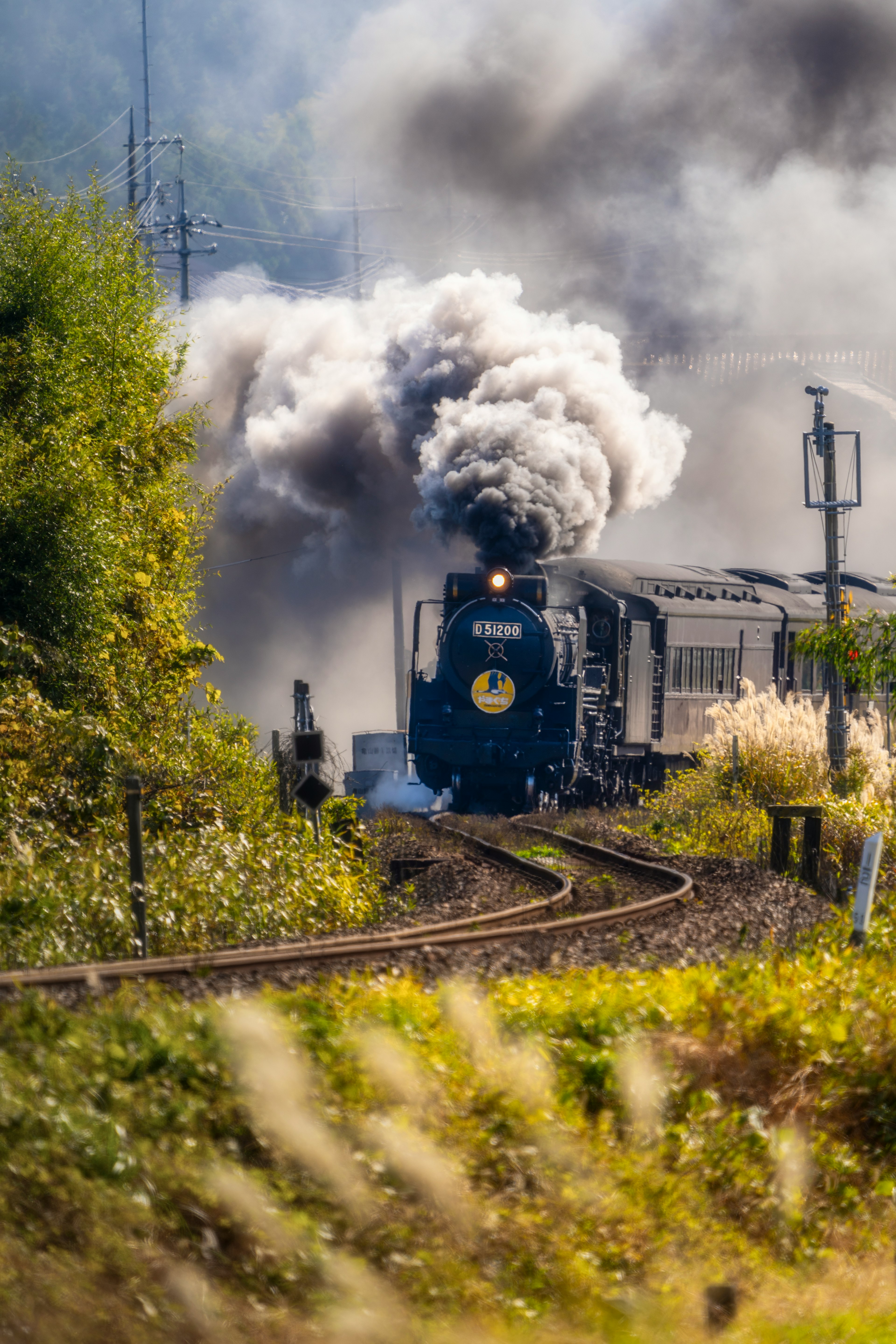 Retro steam locomotive emitting smoke while turning