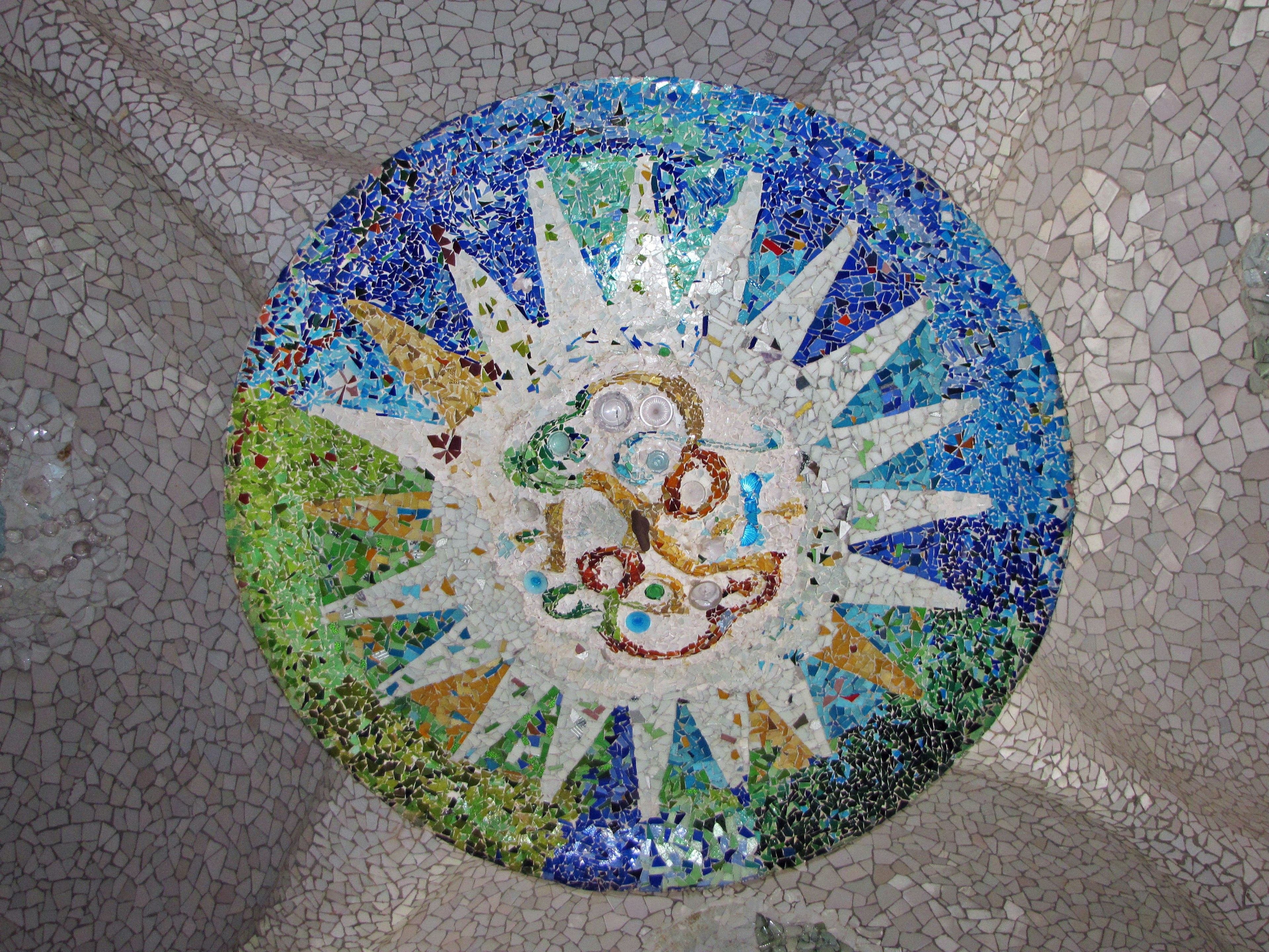 Mosaic featuring a sun design with blue and green tiles