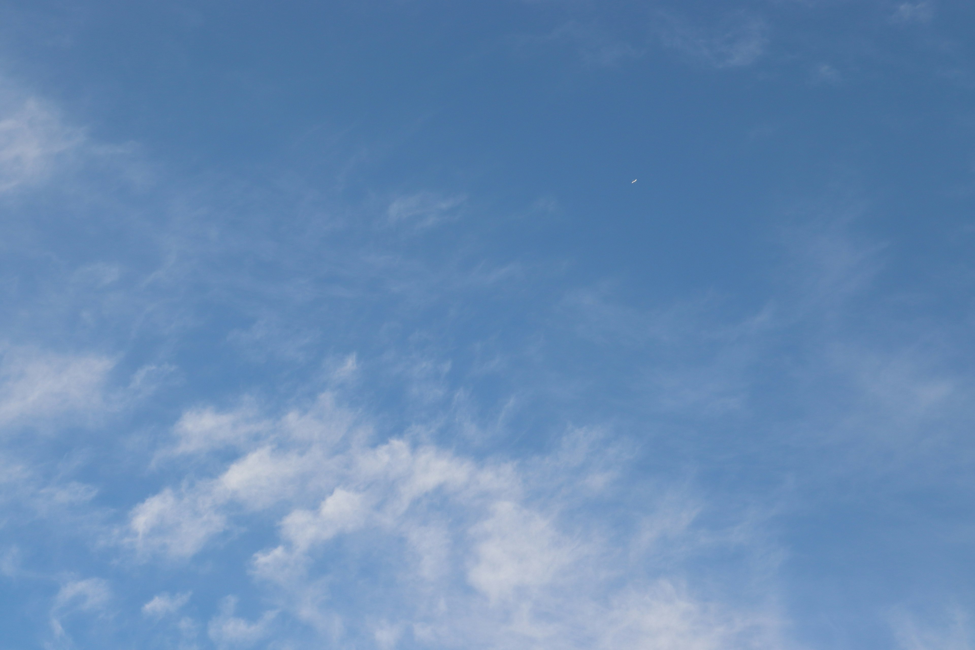 Heller Landschaft mit weißen Wolken, die in einem blauen Himmel treiben