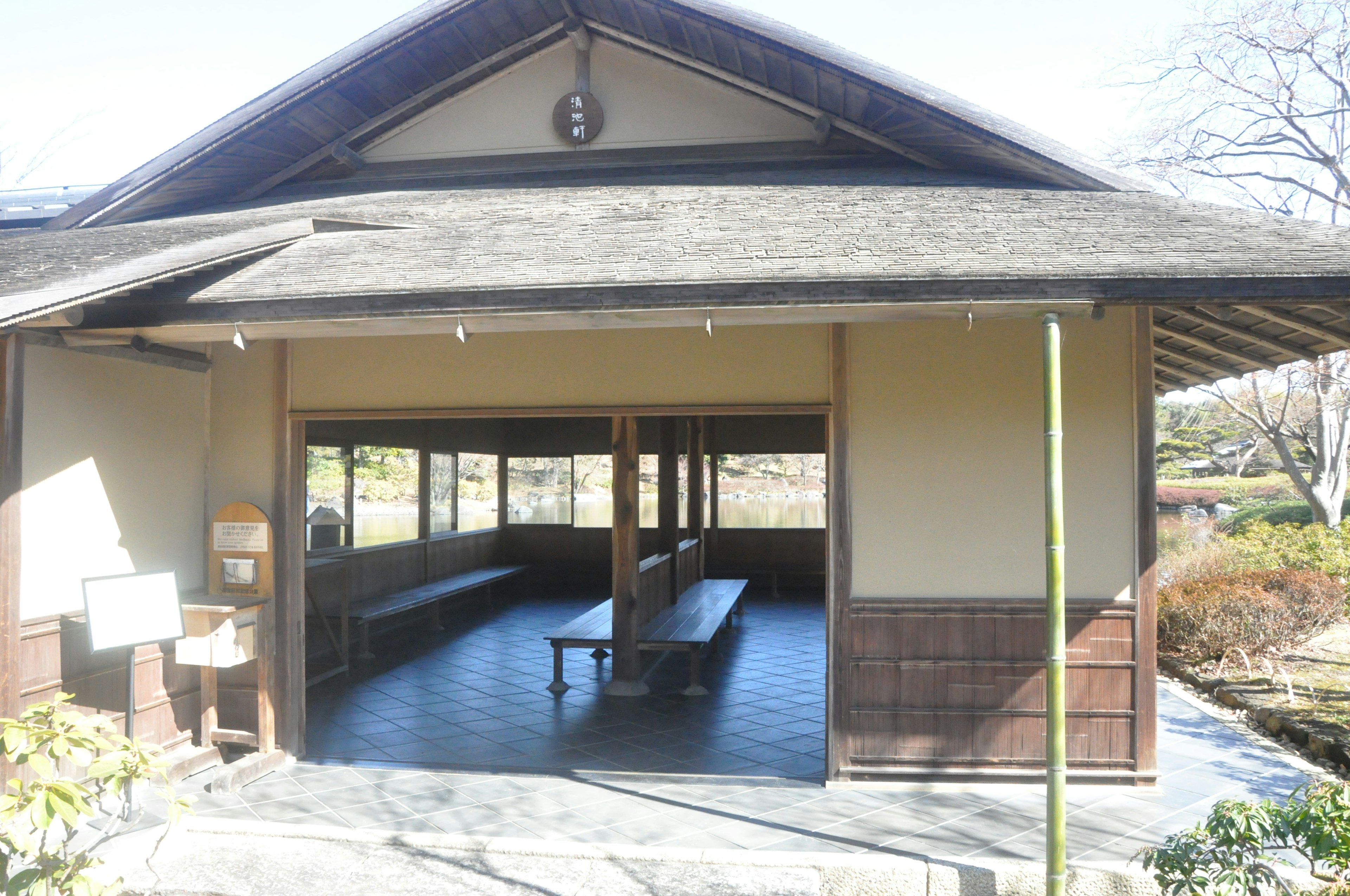 Esterno di un edificio giapponese tradizionale con un design spazioso che si affaccia su un cortile panchine e pavimento in legno luce naturale che entra