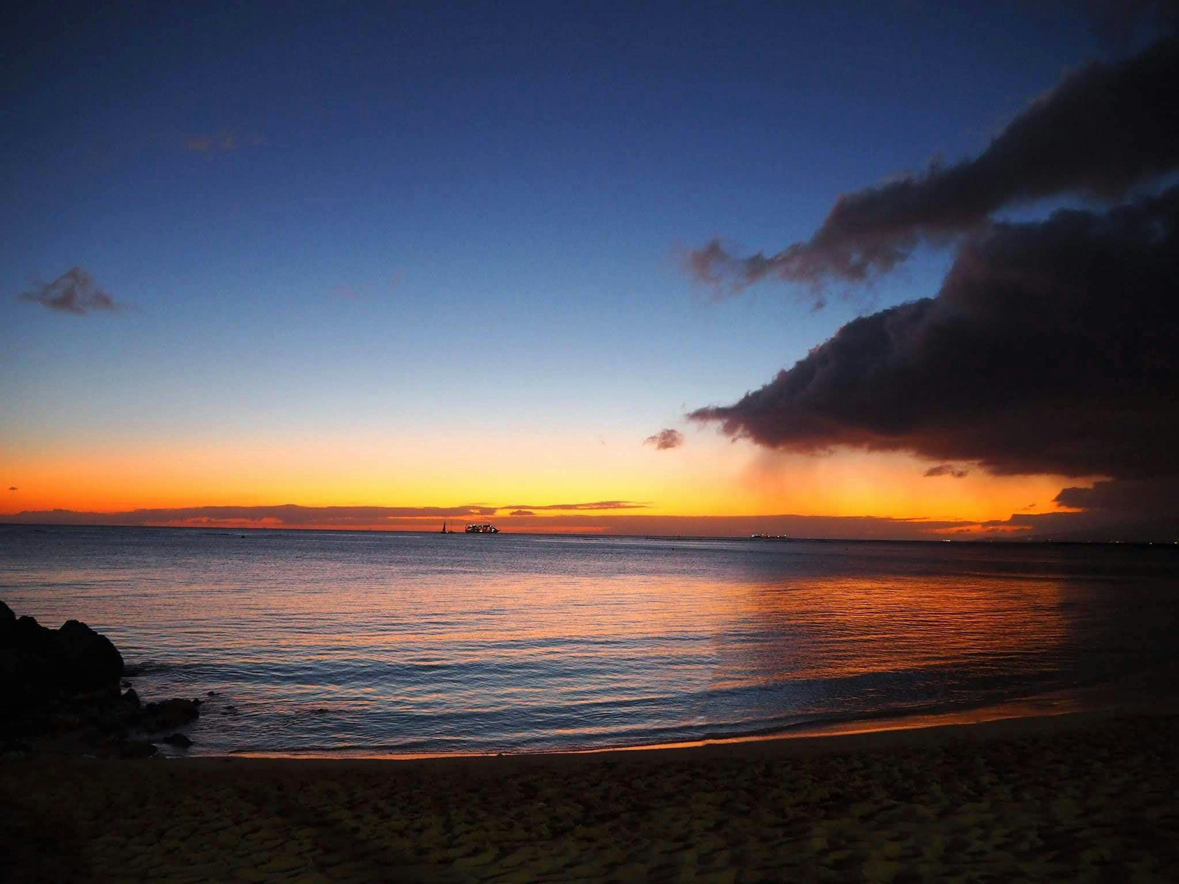 Coastal sunset scene with a gradient from blue to orange