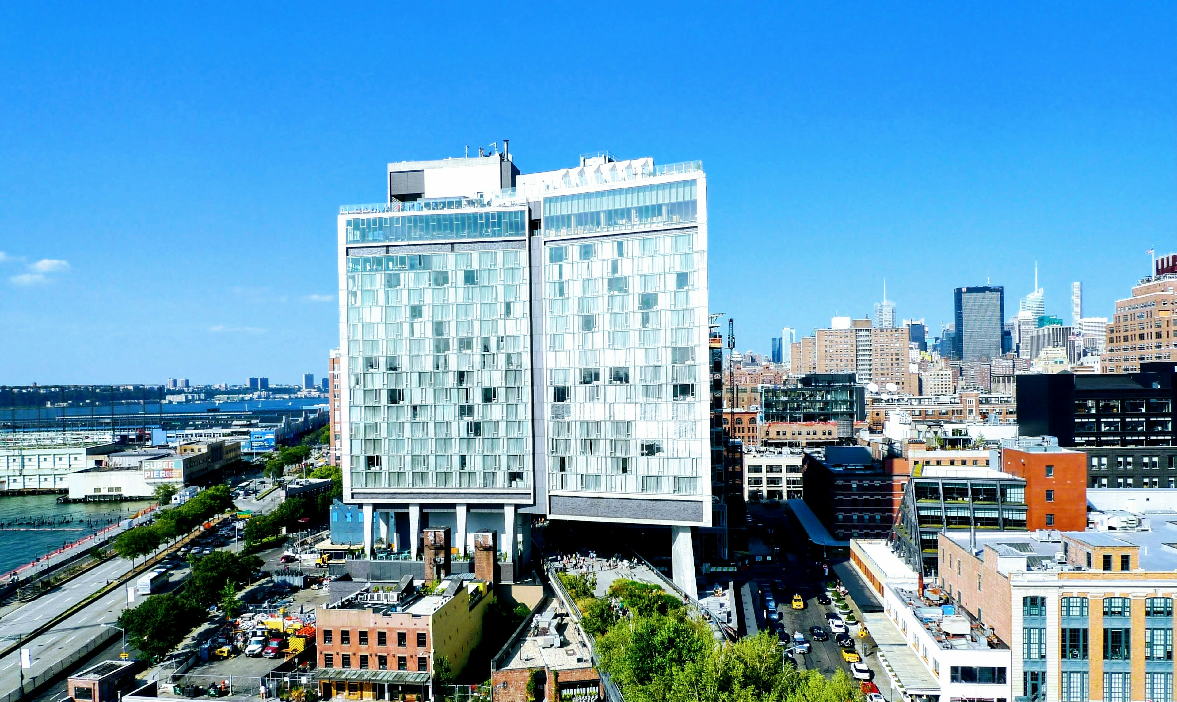 Edificio moderno bajo un cielo azul con horizonte urbano