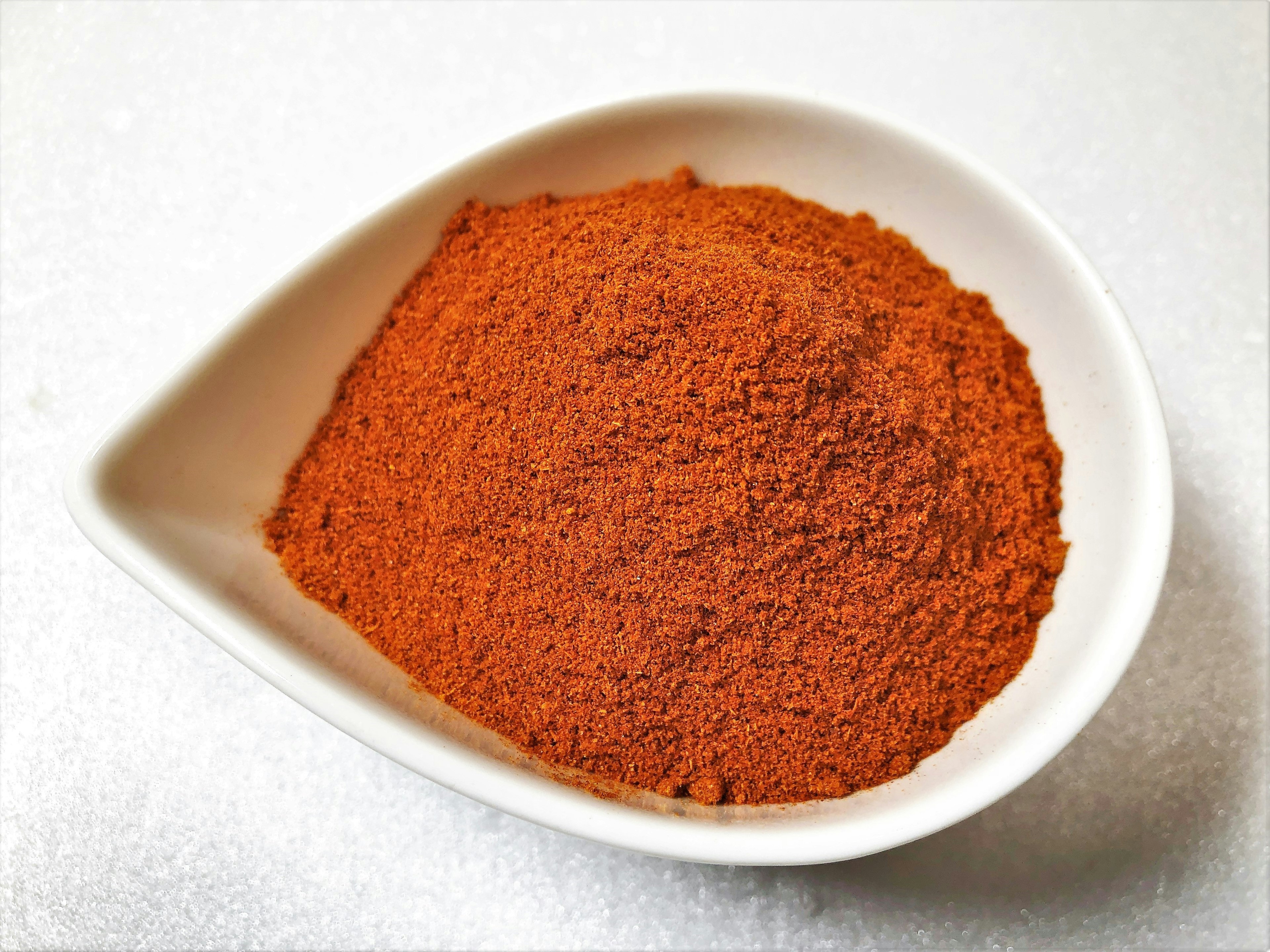 Red spice powder in a white dish