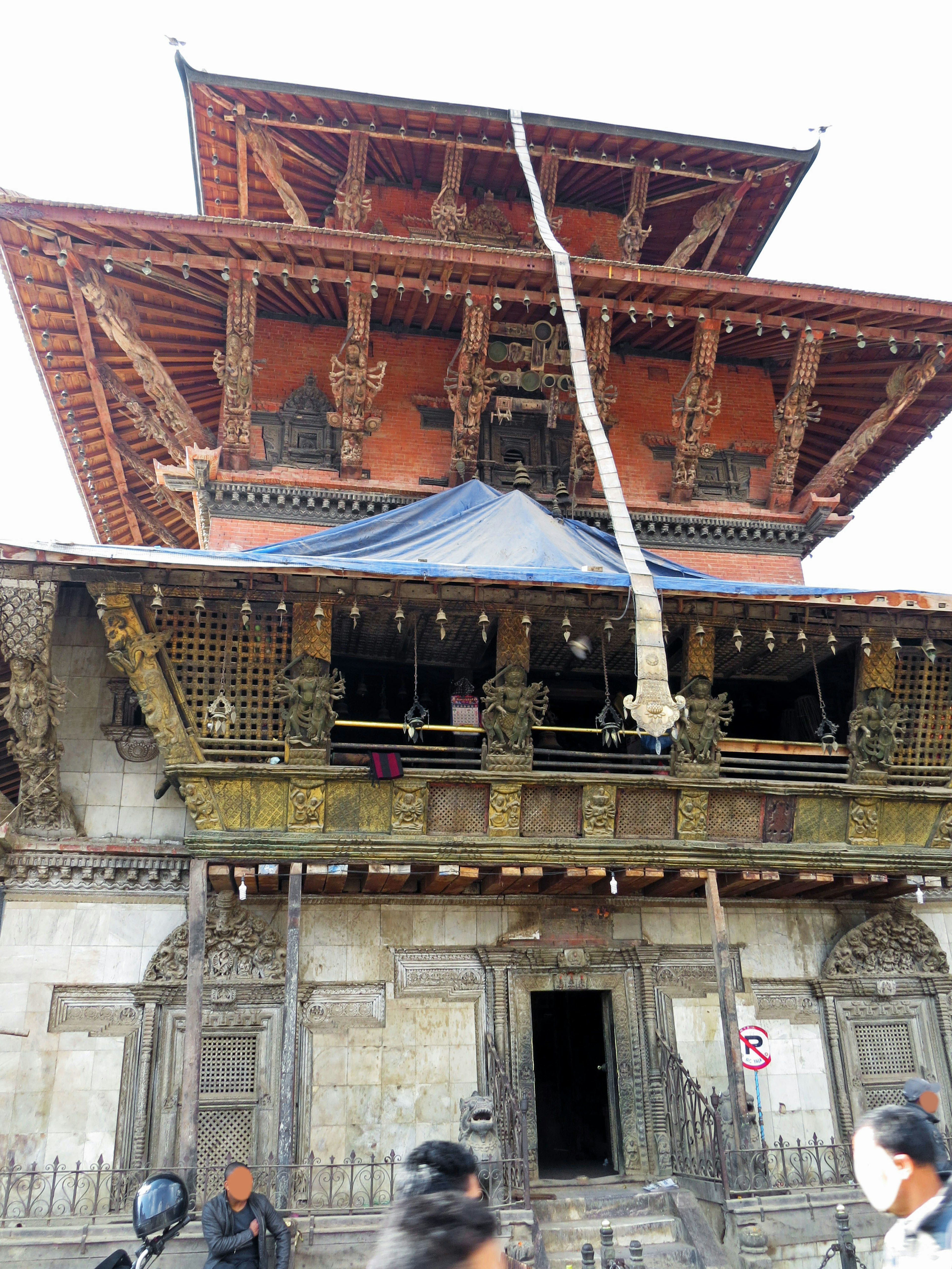 Extérieur d'un temple népalais traditionnel avec des sculptures en bois complexes et un toit rouge