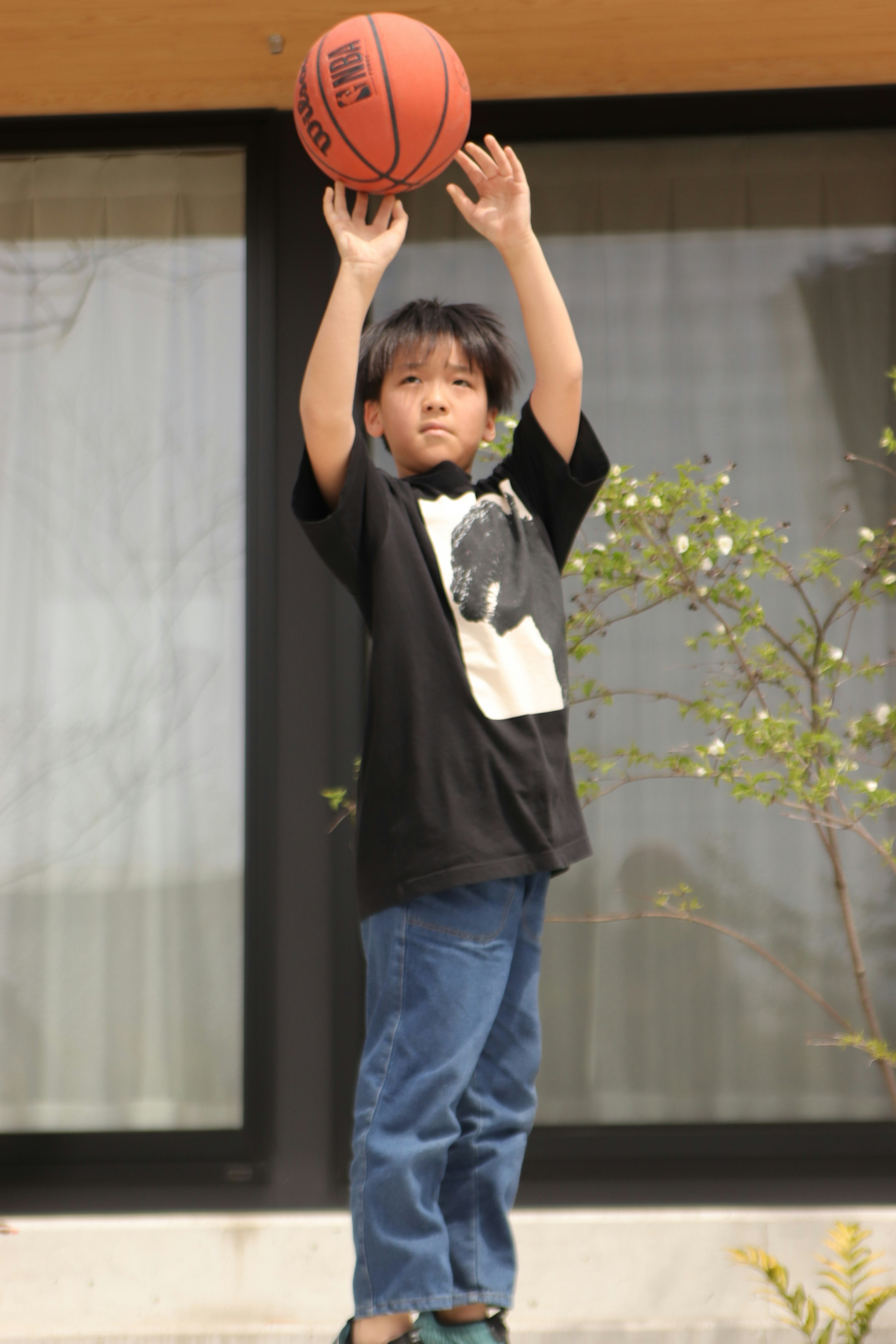 A boy preparing to shoot a basketball outdoors