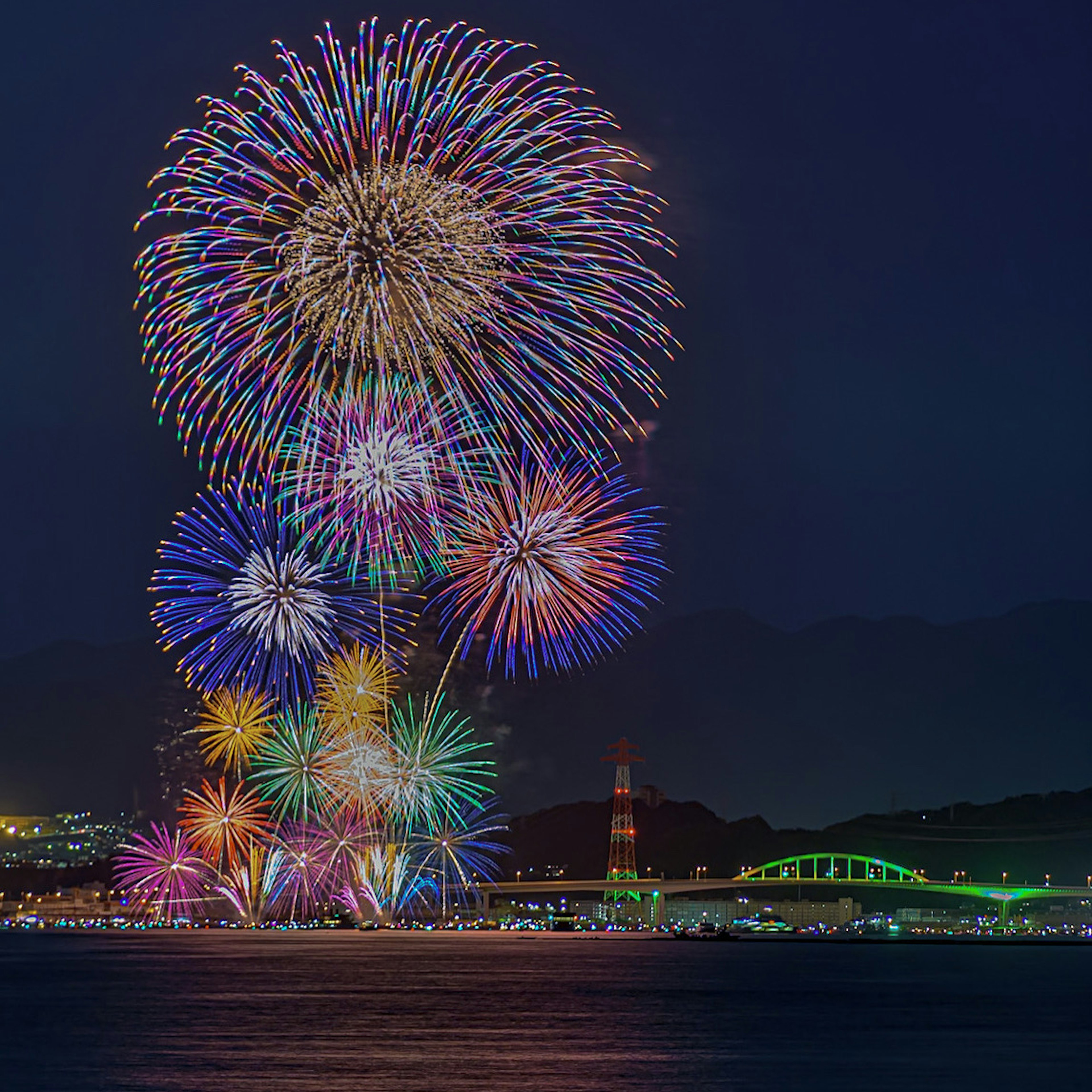 Fuochi d'artificio colorati che esplodono nel cielo notturno sopra il mare