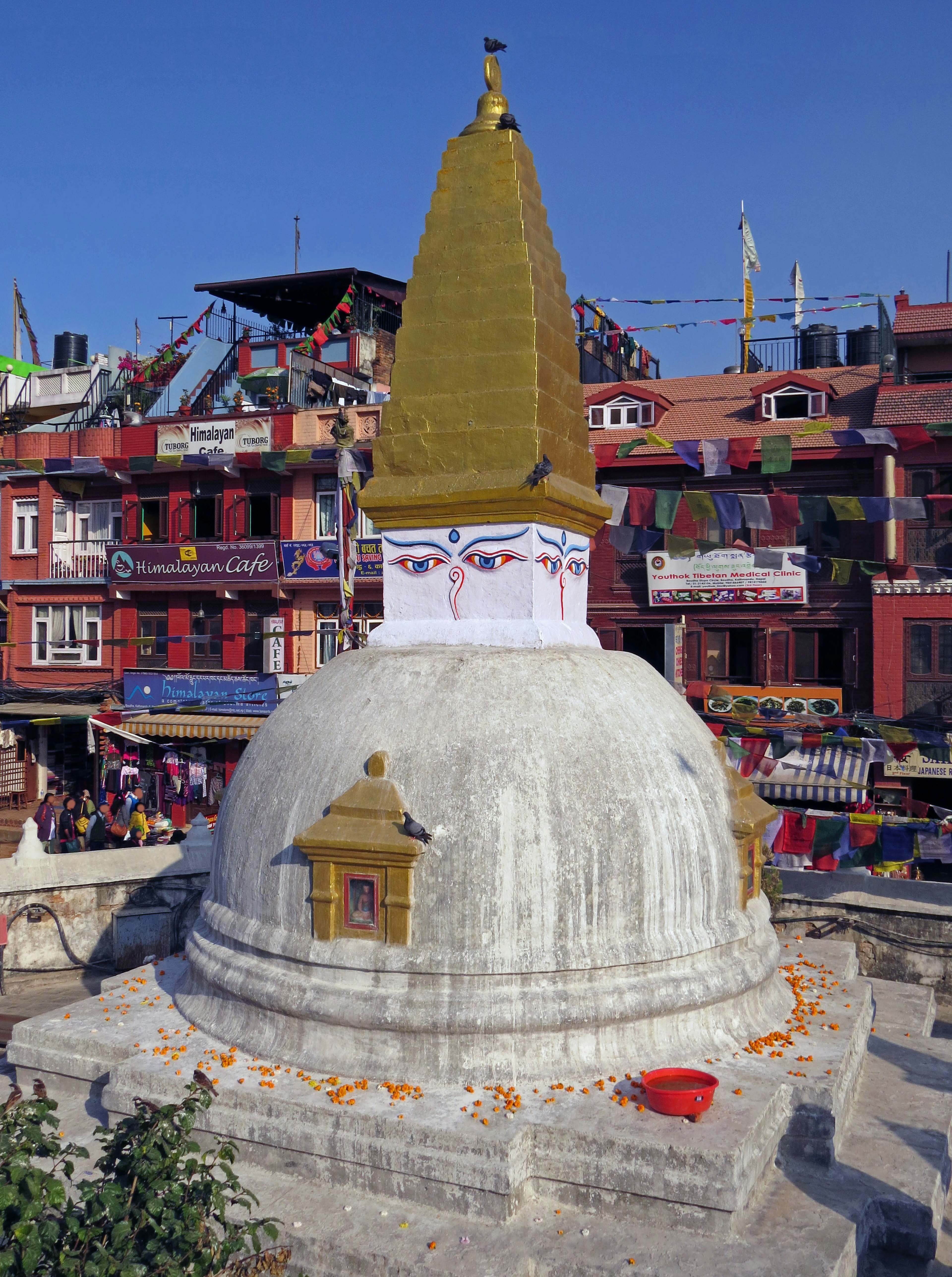 Stupa with golden spire in Kathmandu surrounded by colorful buildings