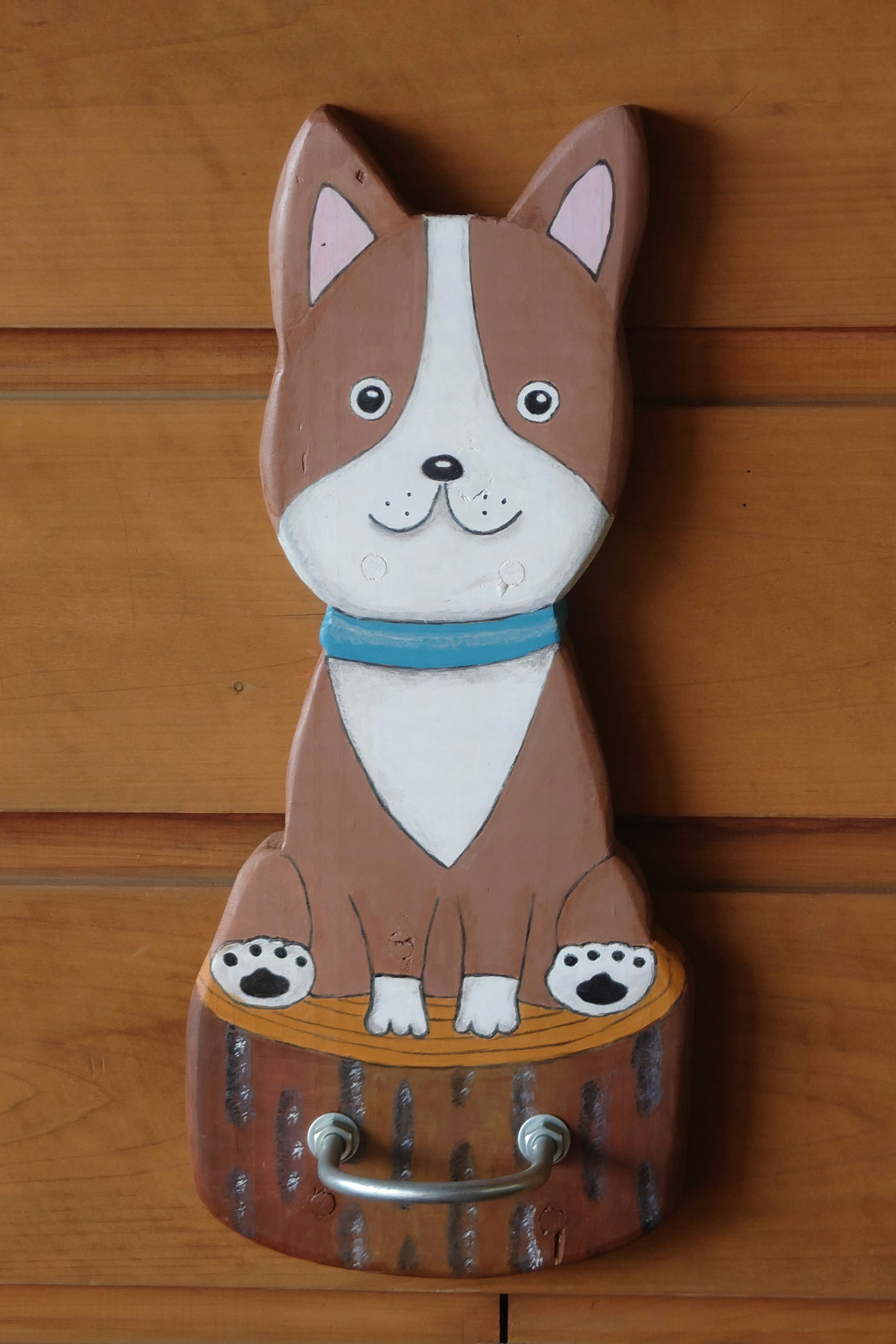 A wooden wall hook featuring a cute dog design with a blue collar